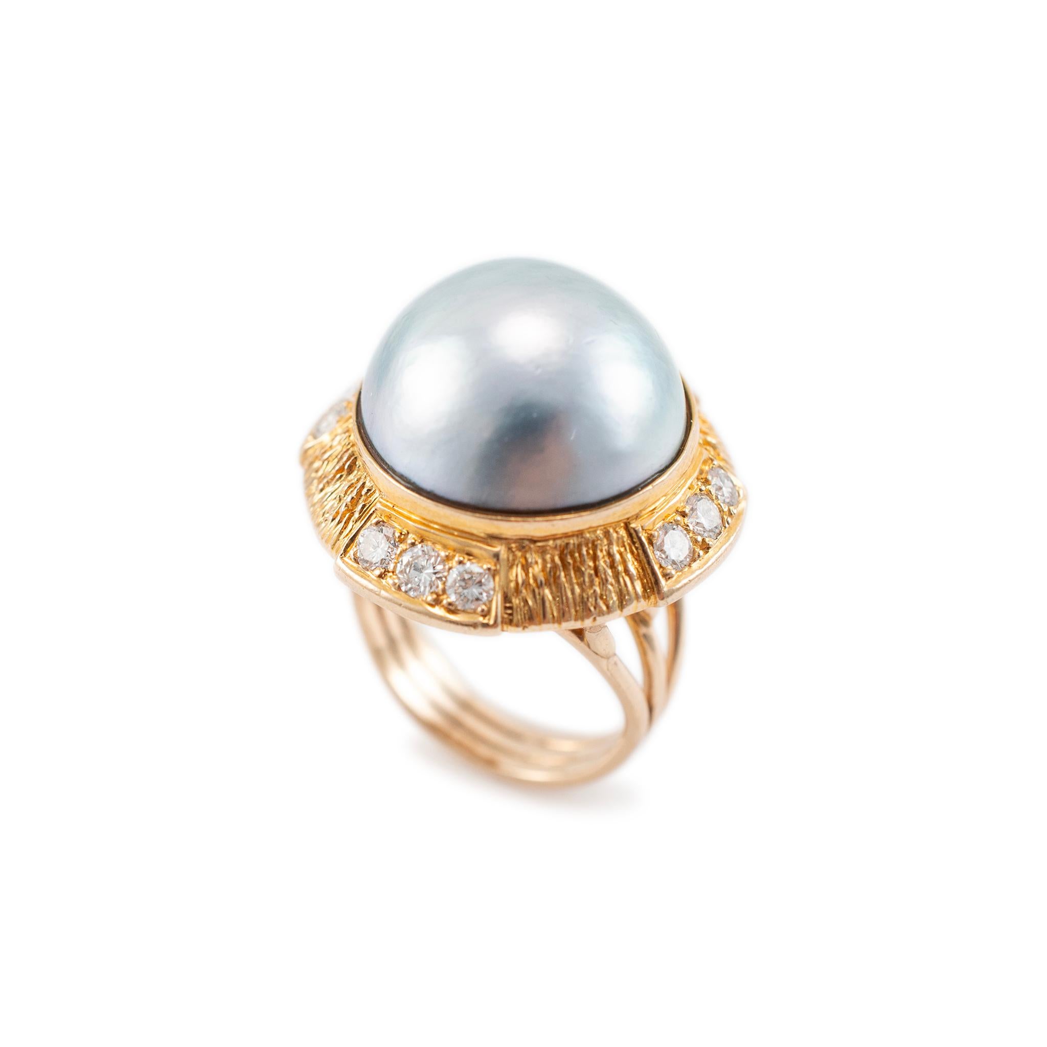 Gender: Ladies

Metal Type: 18K Yellow Gold 

Size: 6.25

Diameter: 24.65 mm

The shank maximum width: 4.70 mm

Weight: 11.90 Grams

One ladies custom made textured & polished 18K yellow gold diamond and pearl vintage, cocktail, halo ring with a