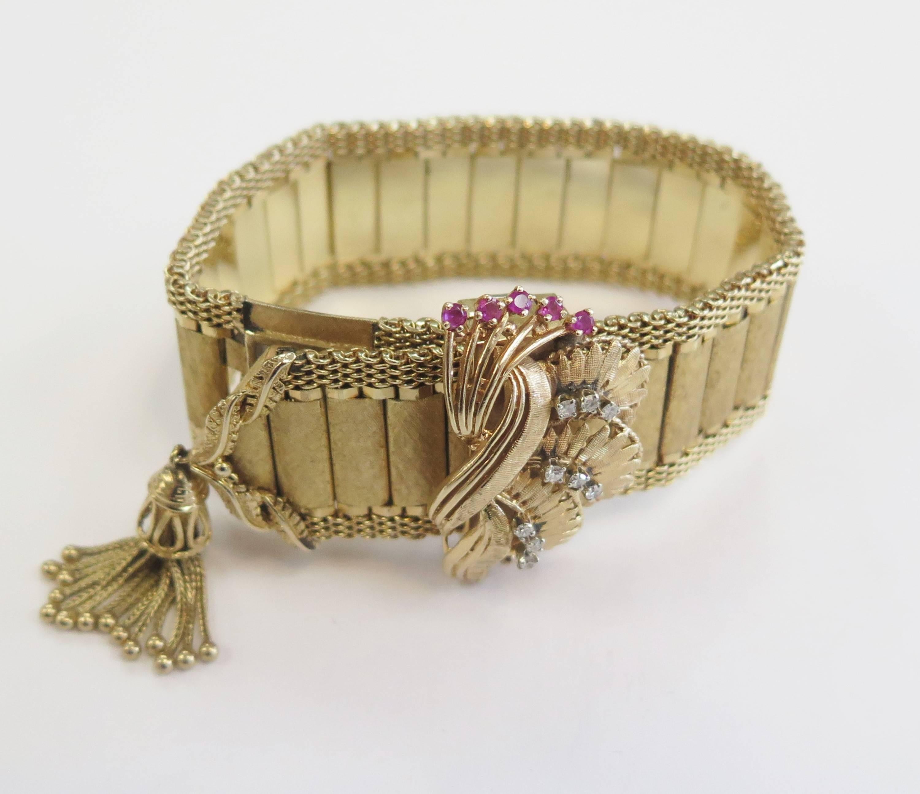 This fabulous 14 karat yellow gold, Diamond and Ruby Buckle Watch/Bracelet from the 1950s era is a rare find. It's designed to look like a belt buckle. The 