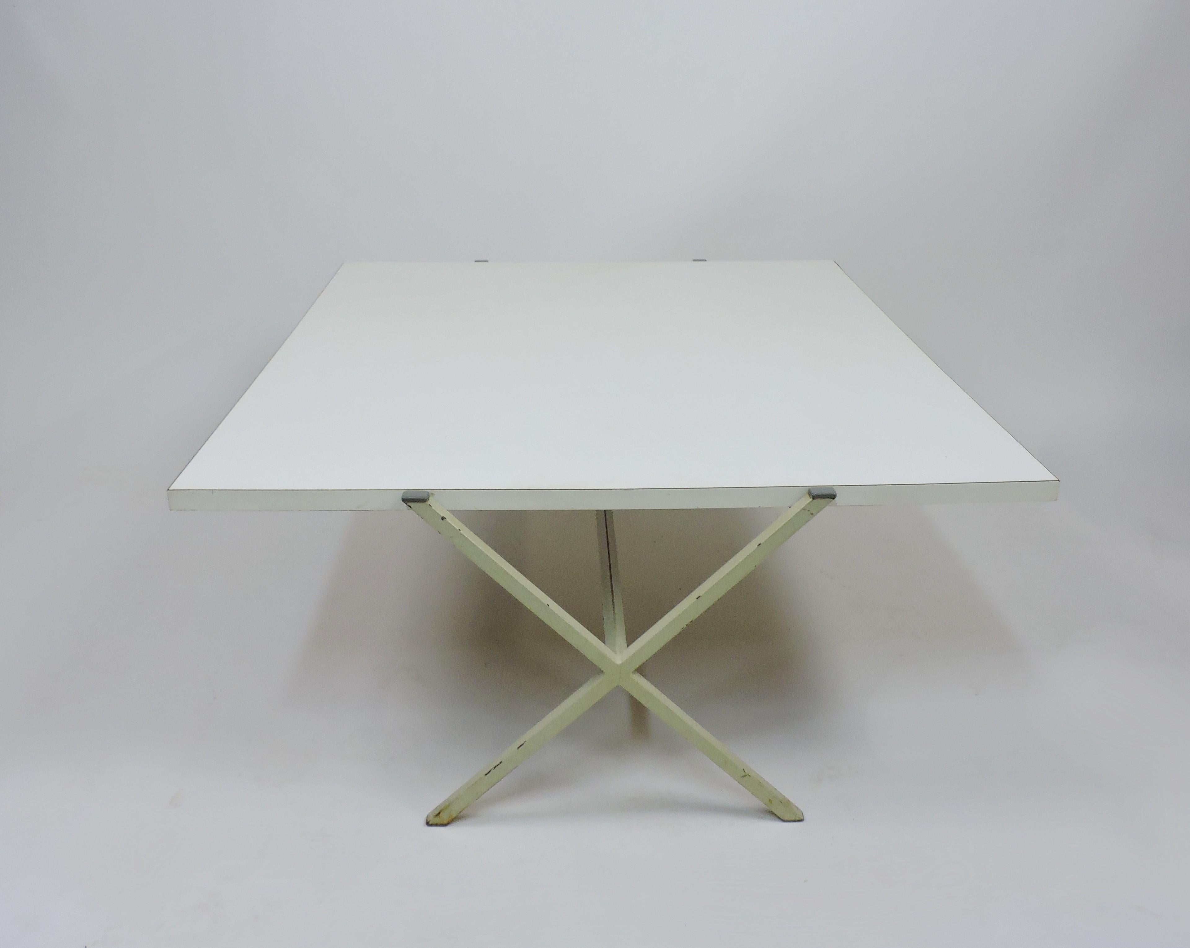Clean and crisp architectural style coffee table designed by renowned architect, Radislav Rado and manufactured by Knoll and Drake. This rare minimalist table has a white laminate top and an enameled steel base in an X form. It was manufactured as