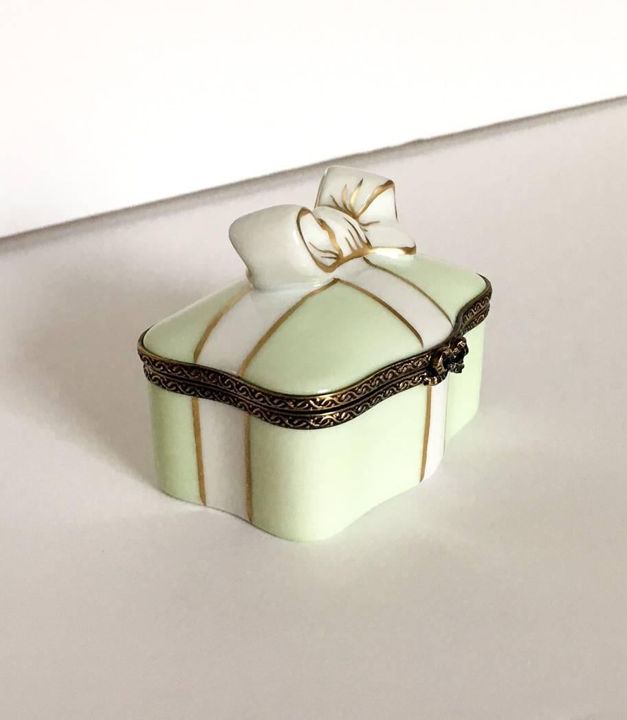 Delightful French Limoges box with brass hardware, hand-painted in France by Peint Main. Box has a bow decoration at the clasp with a hand-painted interior bow on the inside bottom of the pillbox. Perfect for a Mother's Day gift, or for the Limoge