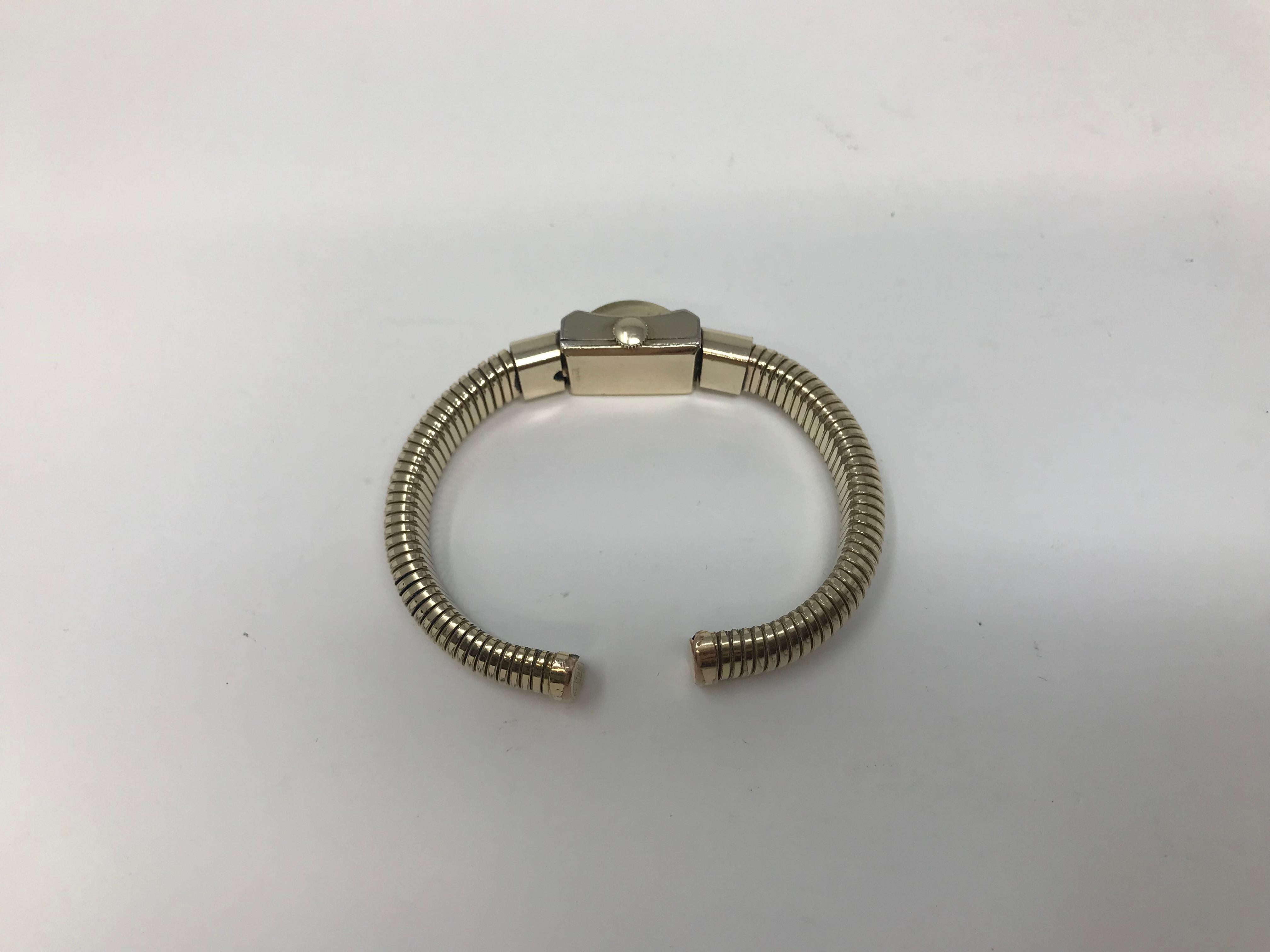 17 Jewels Alki Mechanical Movement 50-8, Swiss Made, with 1/20 12k Gold Filled Henry Pommier Coil Bracelet, Case measures about 15 x 18.5mm. Watch Running, Age wear and surface scratches visible ,consistent with age. White dial with wear