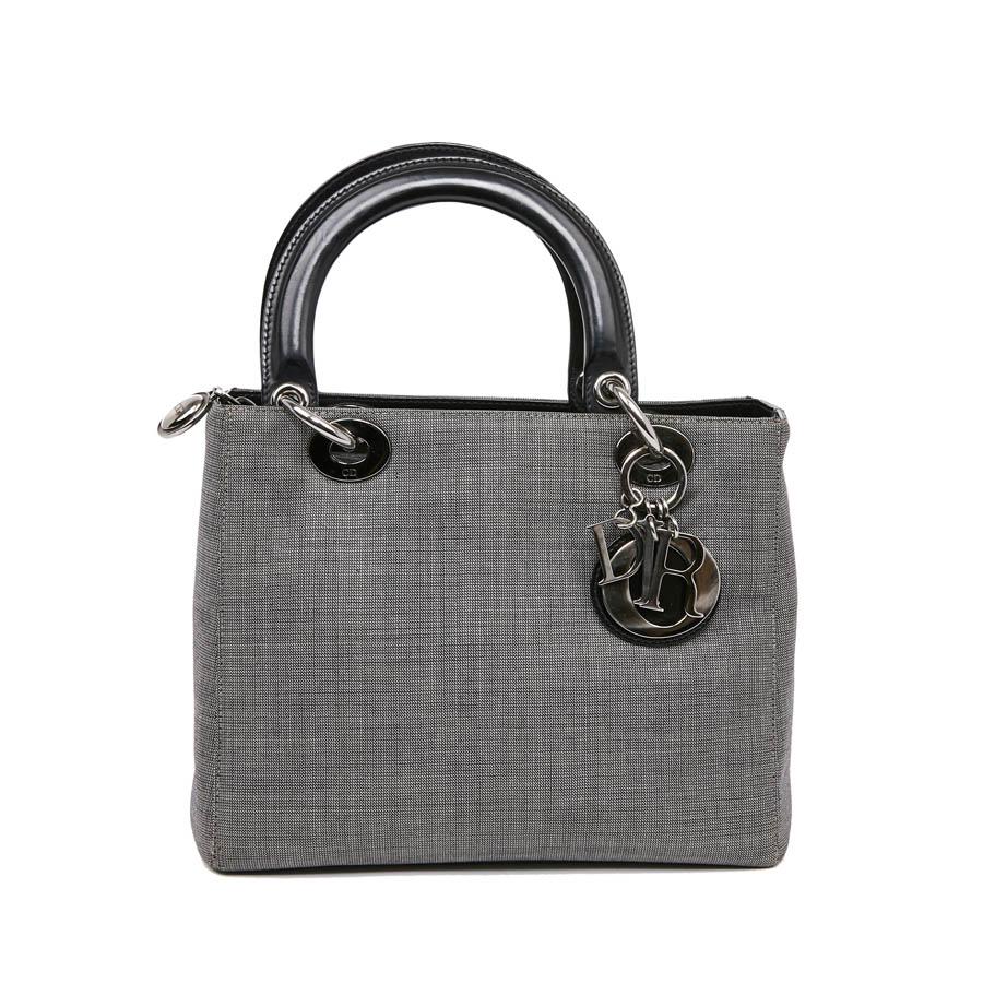 This essential DIOR bag is in gray fabric. It is carried in the hand by a double handle in black leather or on the shoulder with a removable strap. It has a zipper. The jewelry is made of matt metal. It is in very good condition, no wear on the