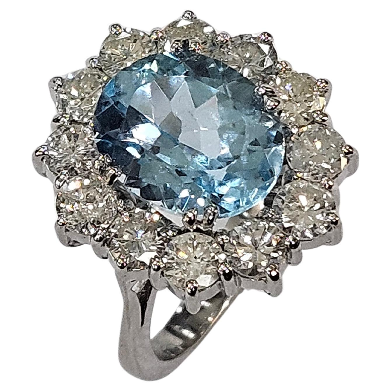 Imponente Cluster Ring Lady Di realizzato a mano in oro bianco 18kts/750mm, con galleria di fili tondi e base decrescente. Al centro Sky Blue Topaz Oval (taglio misto) da 6,21 Carati (12,09 x 9,98x 6,83 mm) Incastonato in quattro doppie griffe e 12