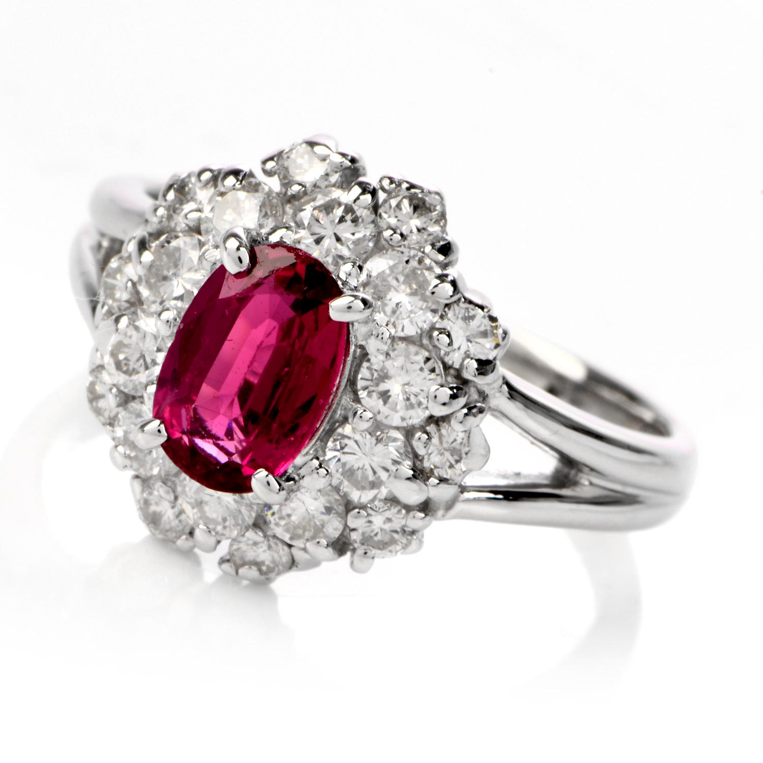 This beautiful ruby and diamond ring is crafted in solid platinum, weighing 6.5 grams and measuring 12mm x 6mm high. Centered with one oval shaped prong-set ruby, weighing approximately 0.96 carats. Further accented by a clustered halo of 22