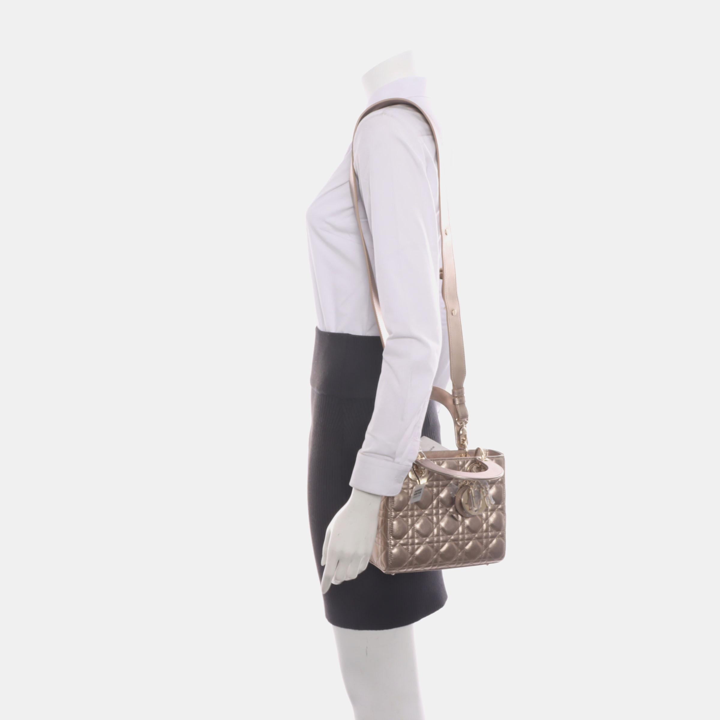 Accentuate your look with the timeless style of Small Lady Dior My Abcdior, crafted in luxurious Lambskin Leather. This classic bag features a cannage stitch, creating a beautiful silhouette and an instantly recognizable quilted design. It is paired