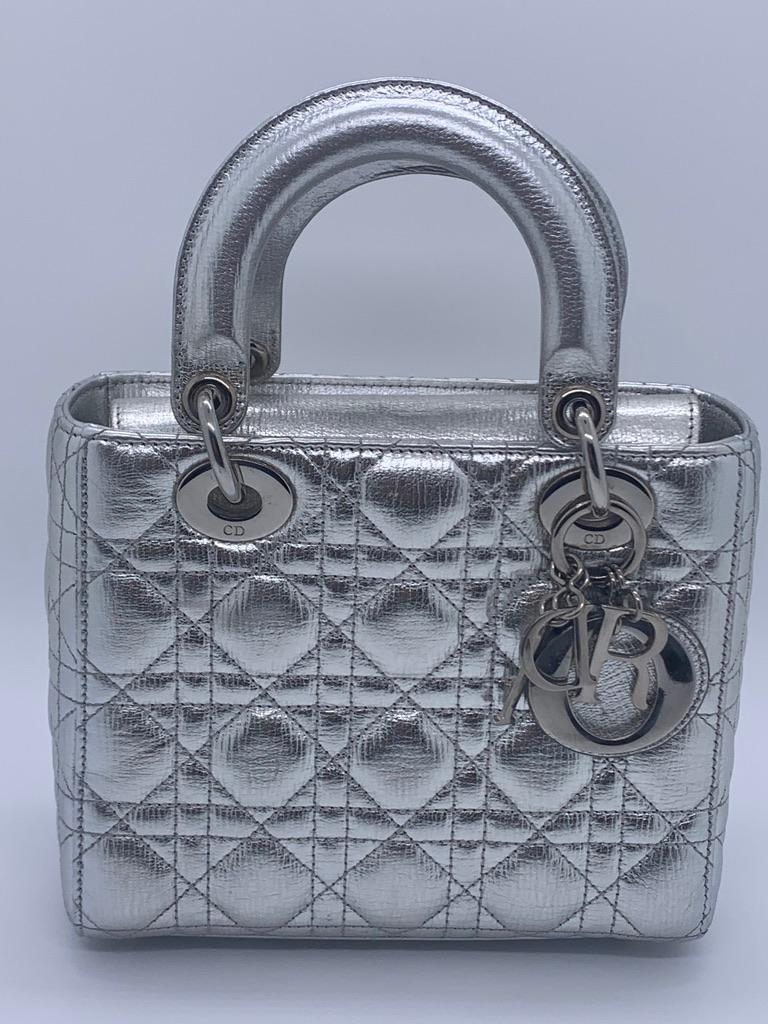 Introducing the Lady Dior ABCdior Small Silver Cannage Lambskin Handbag. Its ABCdior my lady dior design, space silver color, and studded strap make it the epitome of elegance. Plus, its cool color and most popular size make it a must-have accessory