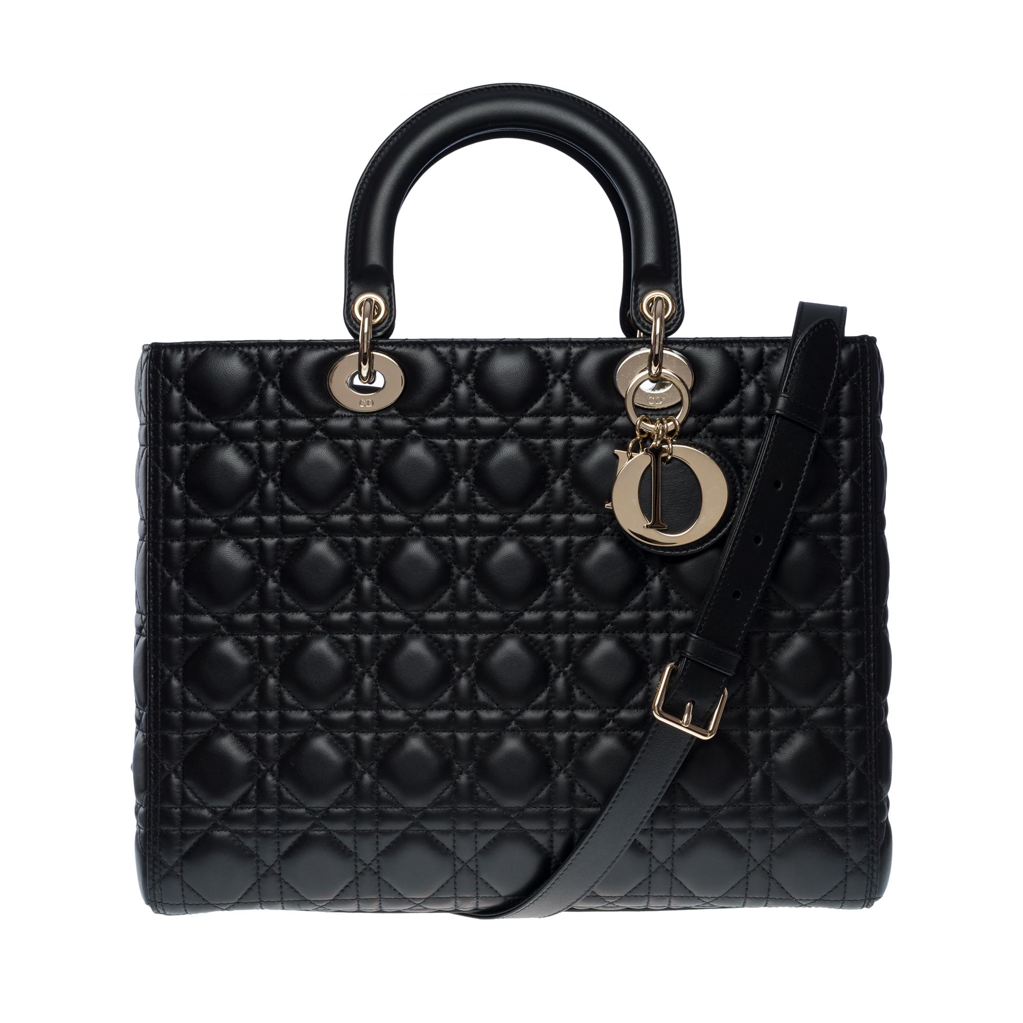 Superbe sac à main Lady Dior Grand Model (GM) en cuir cannage noir, quincaillerie en métal argenté, double poignée en cuir noir, bandoulière amovible en cuir noir pour porter à la main, à l'épaule ou en bandoulière.

Une fermeture par rabat
Doublure