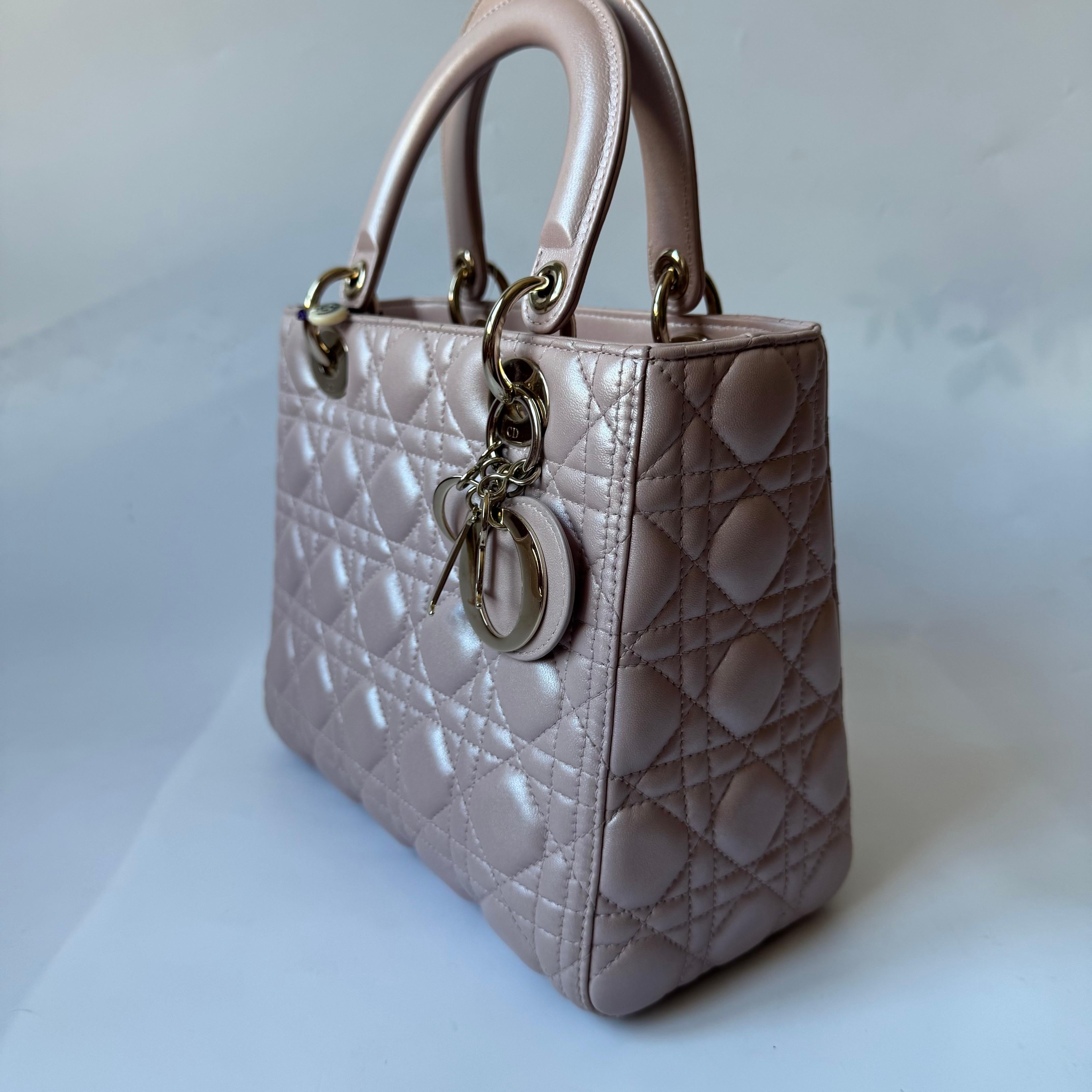 Lady Dior Medium Handbag Pearlescent Pink Cannage Leather Gold Hardware
  These are professional photos of the actual bag offered by Luxbags.
  The Lady Dior bag is an epitome of elegance and beauty. Accentuate your look with the timeless style of