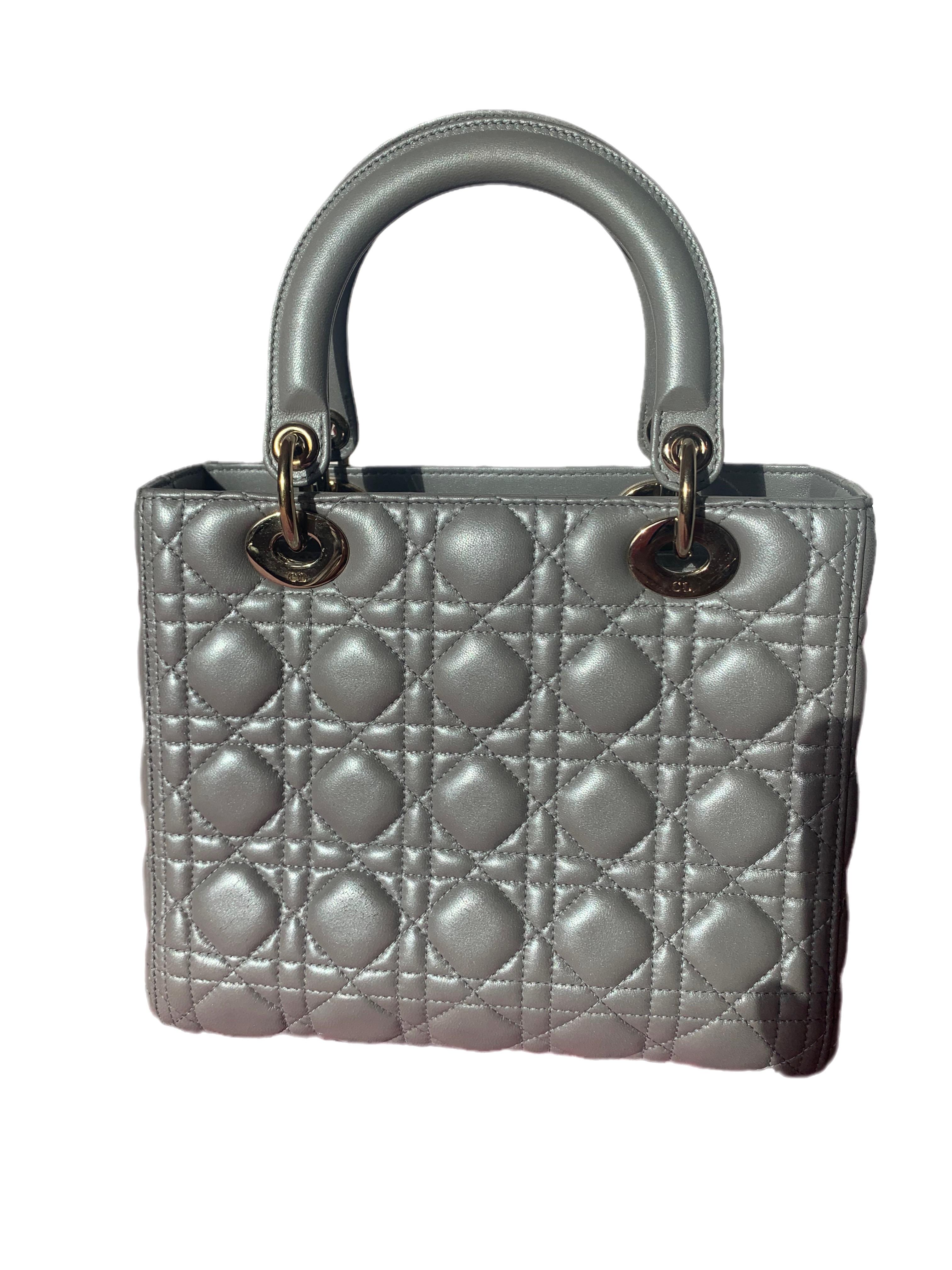 The Lady Dior bag is an epitome of elegance and beauty. Accentuate your look with the timeless style of Medium Lady Dior, crafted in Pearlescent Grey Lambskin Leather. This classic bag features a cannage stitch, creating a beautiful silhouette and