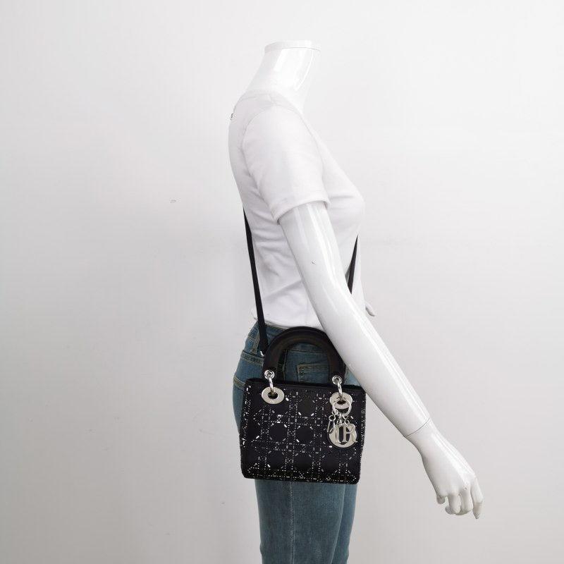Lady Dior Mini Black Silk with Crystals Silver Hardware
 These are professional photos of the actual bag offered
 This mini handbag, made of high-quality black cloth with iconic micro-cannage stitching, is a stylish and elegant accessory for your