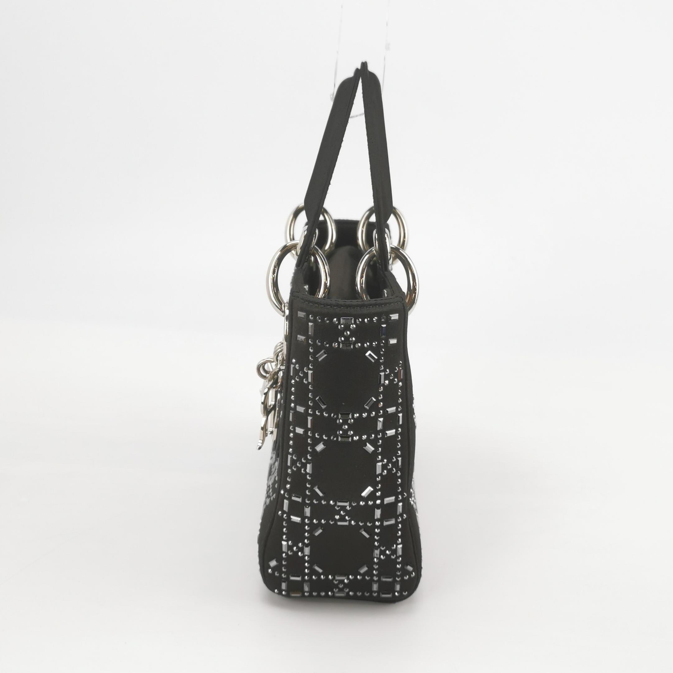 Lady Dior Mini Black Silk with Crystals Silver Hardware
 These are professional photos of the actual bag offered
 This mini handbag, made of high-quality black cloth with iconic micro-cannage stitching, is a stylish and elegant accessory for your