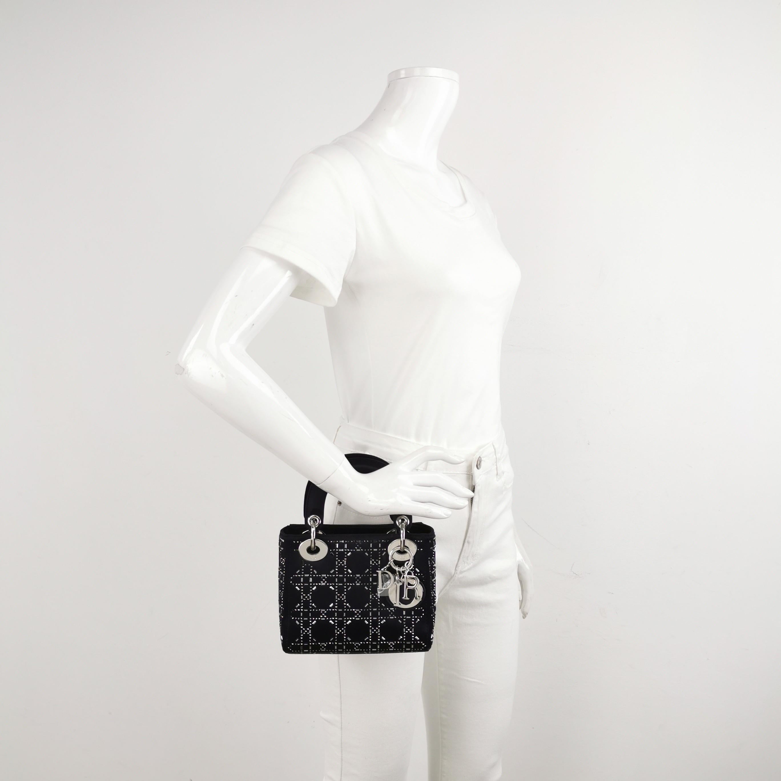 Diese Mini-Handtasche aus hochwertigem schwarzem Stoff mit den ikonischen Mikronähten ist ein stilvolles und elegantes Accessoire für Ihre Garderobe. Sie ist mit kontrastierenden, hellgoldfarbenen Beschlägen verziert. Ein zeitloser Klassiker, der