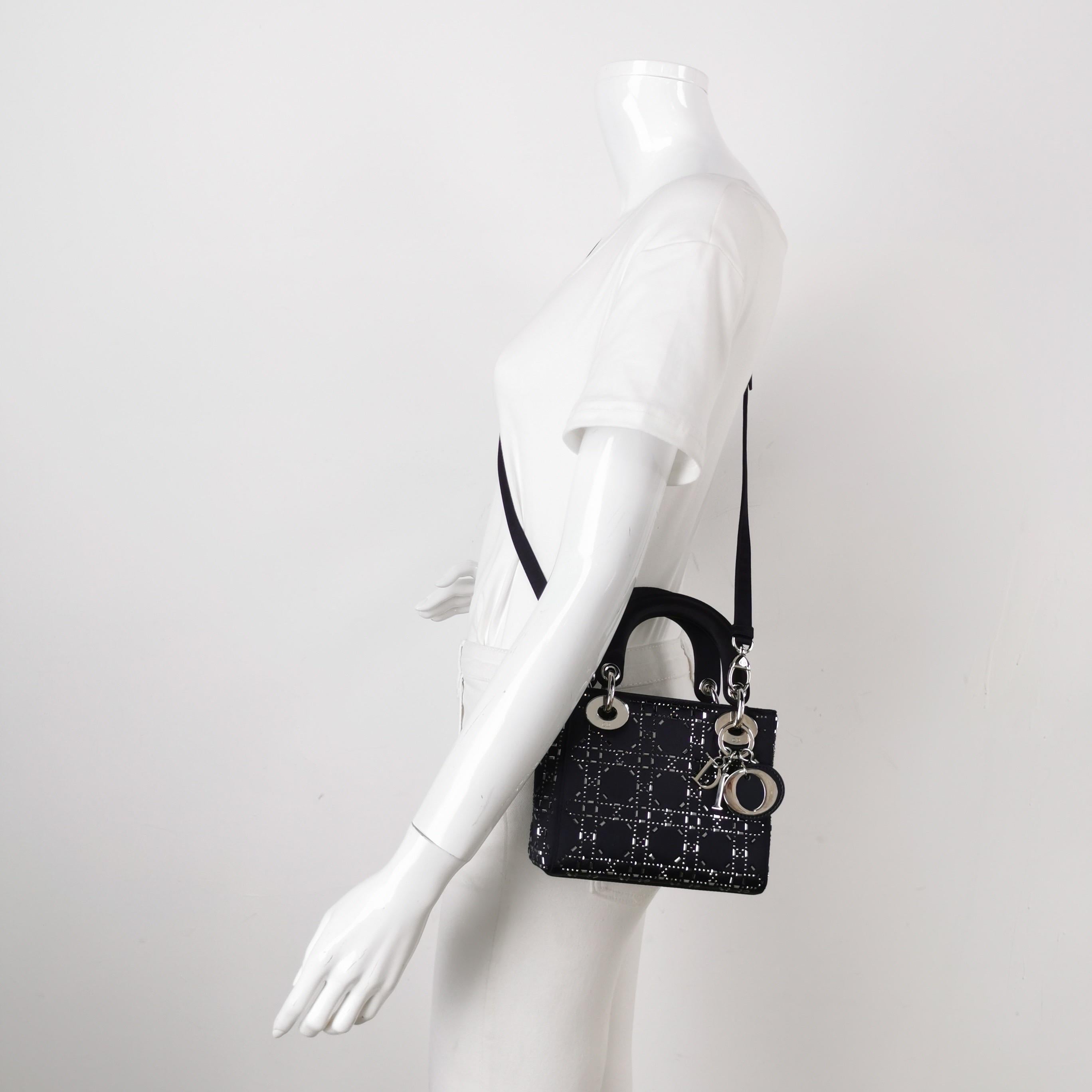 This mini handbag, made of high-quality black cloth with iconic micro-cannage stitching, is a stylish and elegant accessory for your wardrobe. It is adorned with contrasting light gold-toned hardware. the A timeless classic that will elevate your