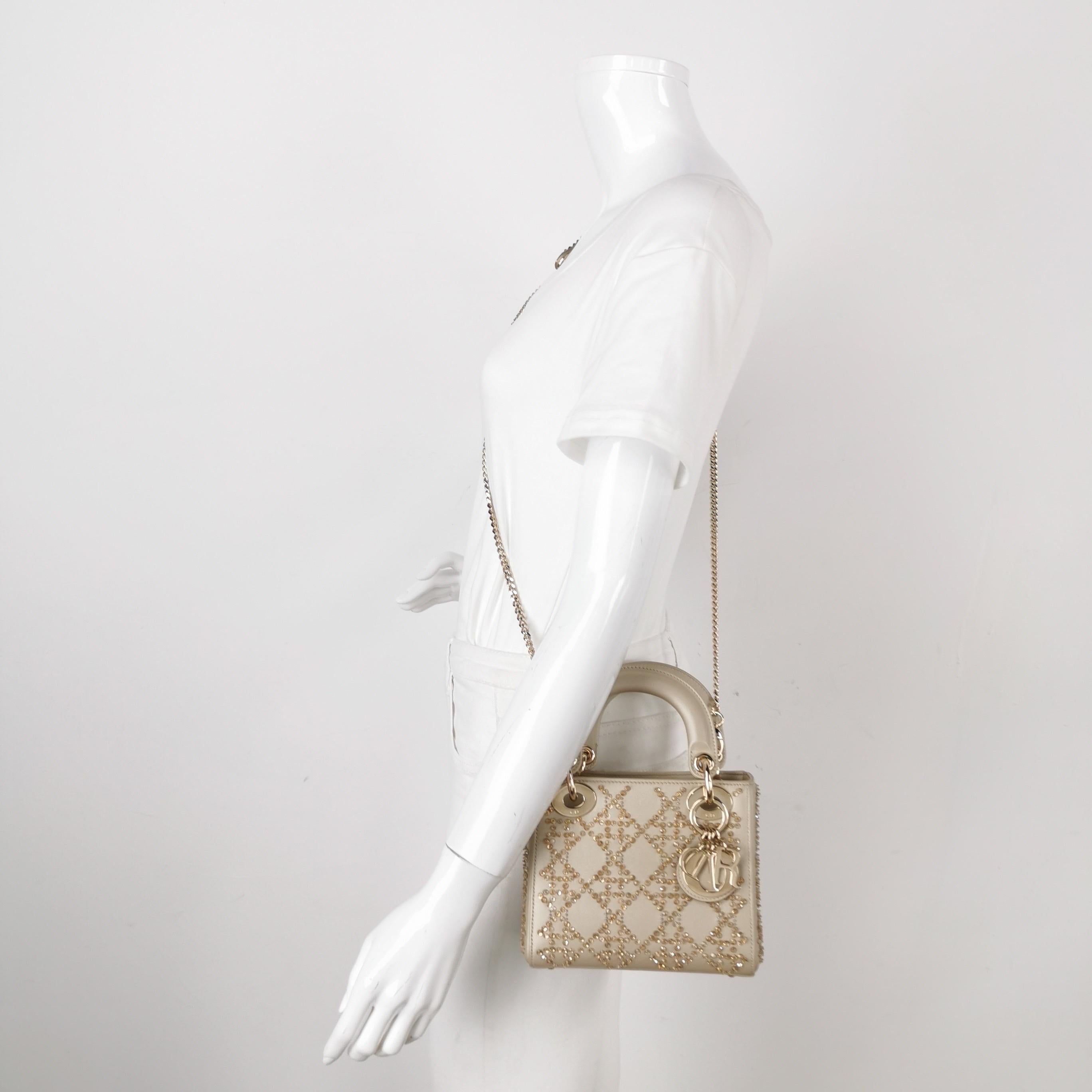 This mini handbag, made of high-quality black cloth with iconic micro-cannage stitching, is a stylish and elegant accessory for your wardrobe. It is adorned with contrasting light gold-toned hardware. the A timeless classic that will elevate your