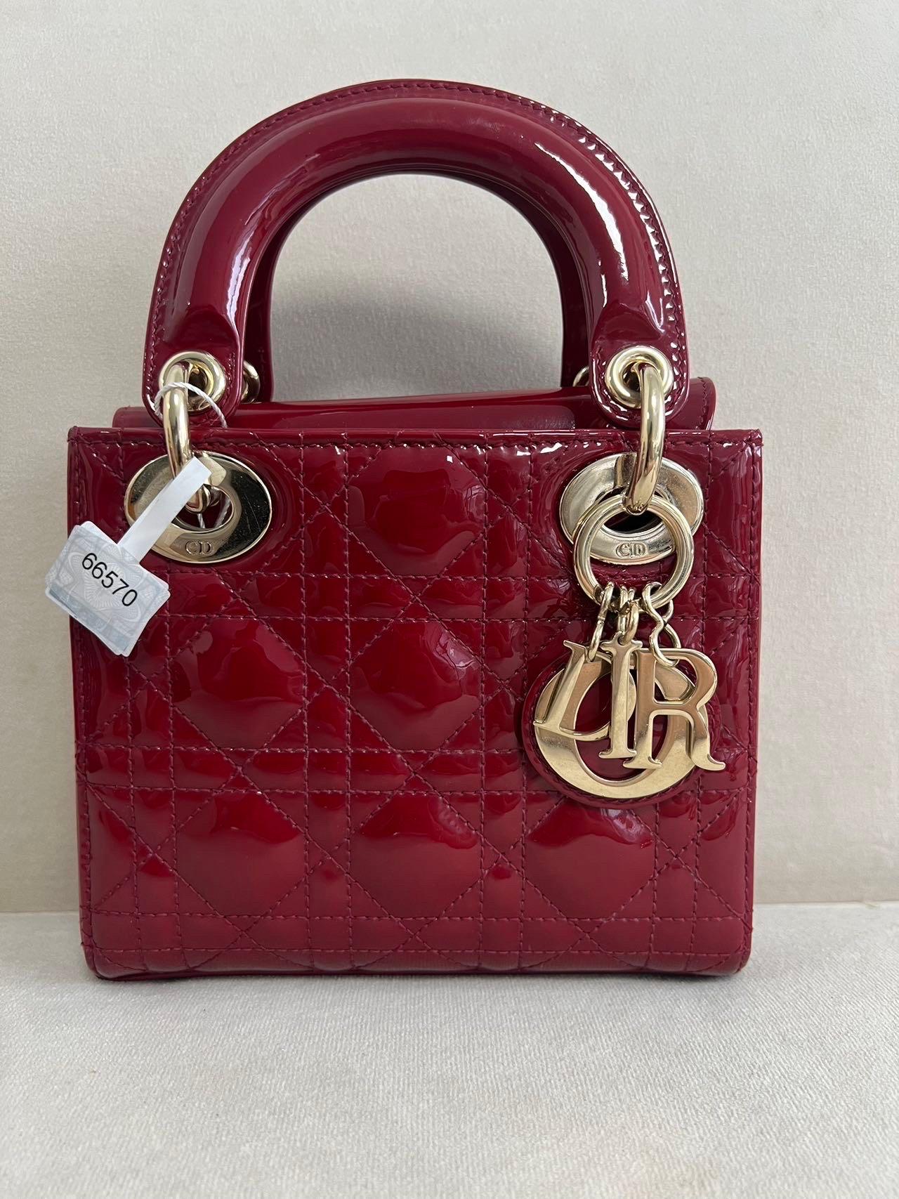 This Lady Dior Mini handbag features a stunning red color in patent leather decorated with gold hardware, gold embellished chain strap, making it an ideal accessory for any stylish woman who dares to make a bold statement with their accessory. The