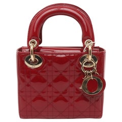 Mini borsa Lady Dior in pelle verniciata rosso borgogna con tracolla a catena dorata