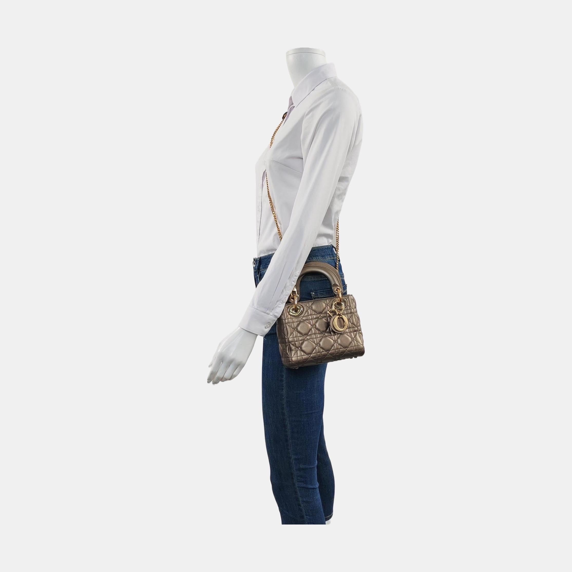 Ce sac classique présente un point de cannage, créant une belle silhouette et un motif matelassé immédiatement reconnaissable. Il est assorti d'une quincaillerie dorée et de charmes D.I.O.R. Doté d'une bandoulière amovible, le sac Lady Dior peut