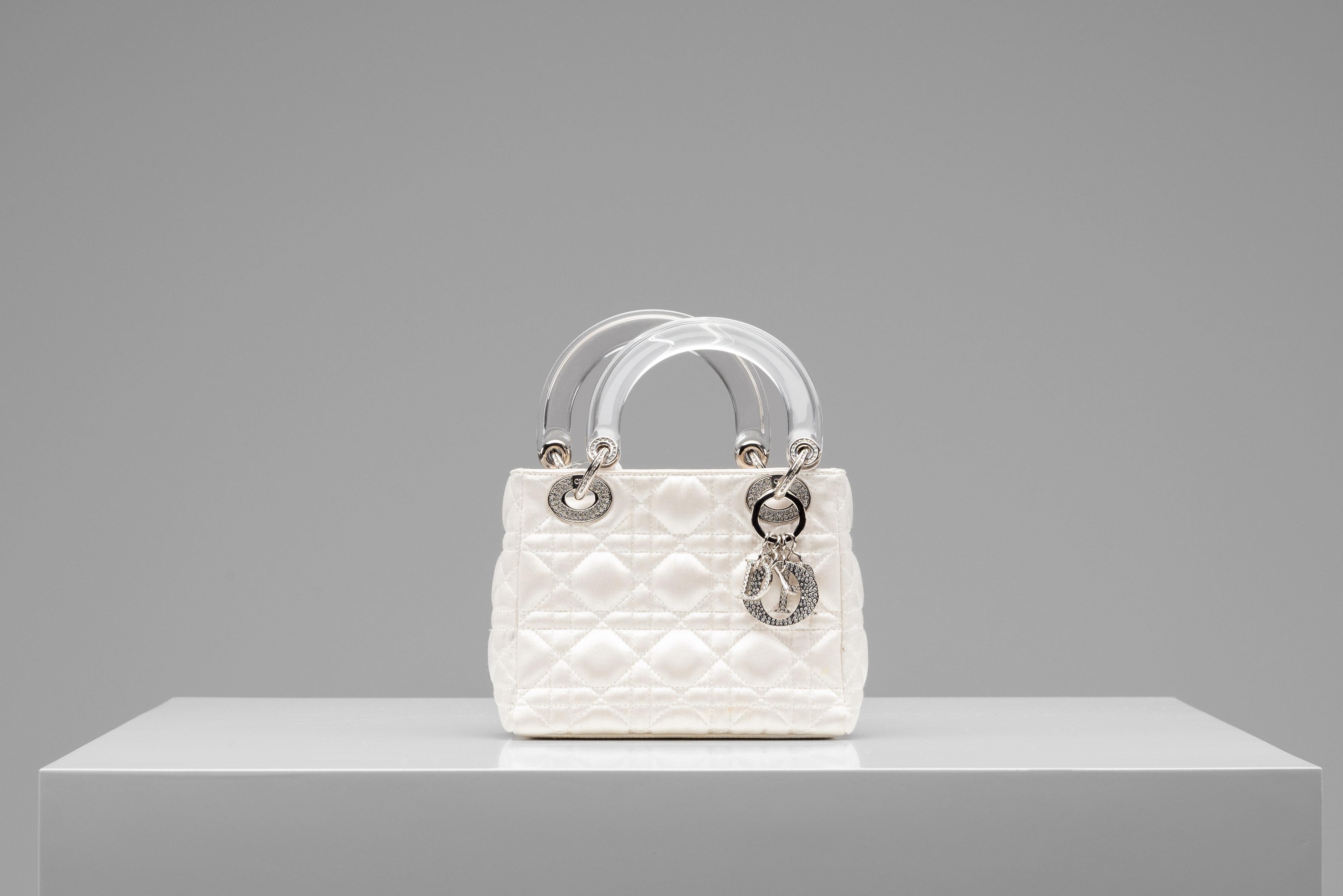 From the collection of SAVINETI we offer this Lady Dior Mini Satin bag:
-    Brand: Dior
-    Model: Lady Dior Mini
-    Color: White/ Pearl
-    Condition: Very Good Condition (spot at the underside of the bag - see images)
-    Materials: White