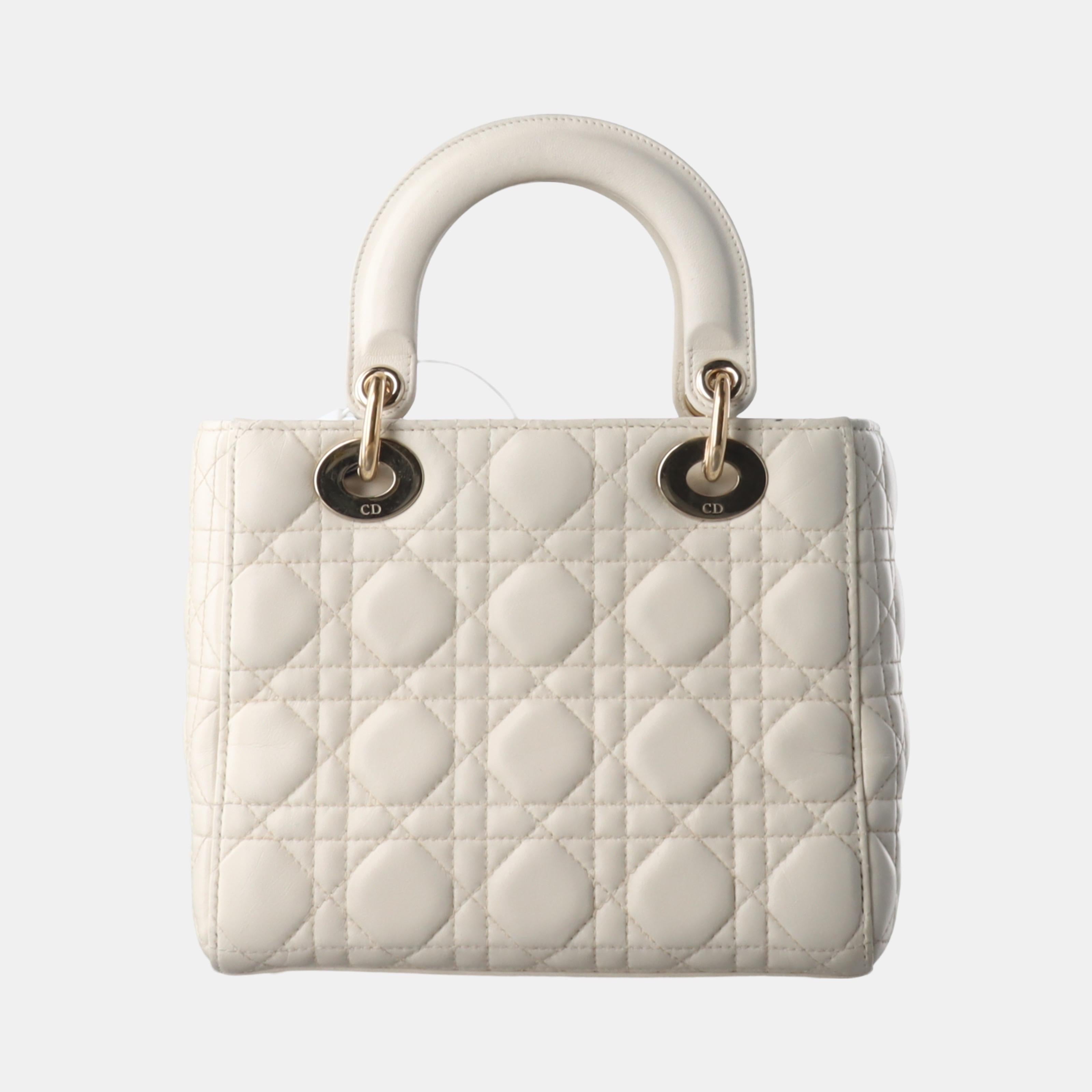 The Lady Dior bag is an epitome of elegance and beauty. Accentuate your look with the timeless style of Small Lady Dior My Abcdior, crafted in Cream White Lambskin Leather. This classic bag features a cannage stitch, creating a beautiful silhouette