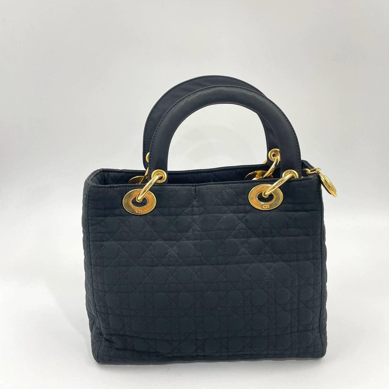 Lady Dior Vintage Medium Black Cloth with Yellow Gold-tone Hardware These are professional photos of the actual bag offered by Luxbags. This large Lady Dior handbag, made of high-quality black cloth with iconic micro-cannage stitching, is a stylish