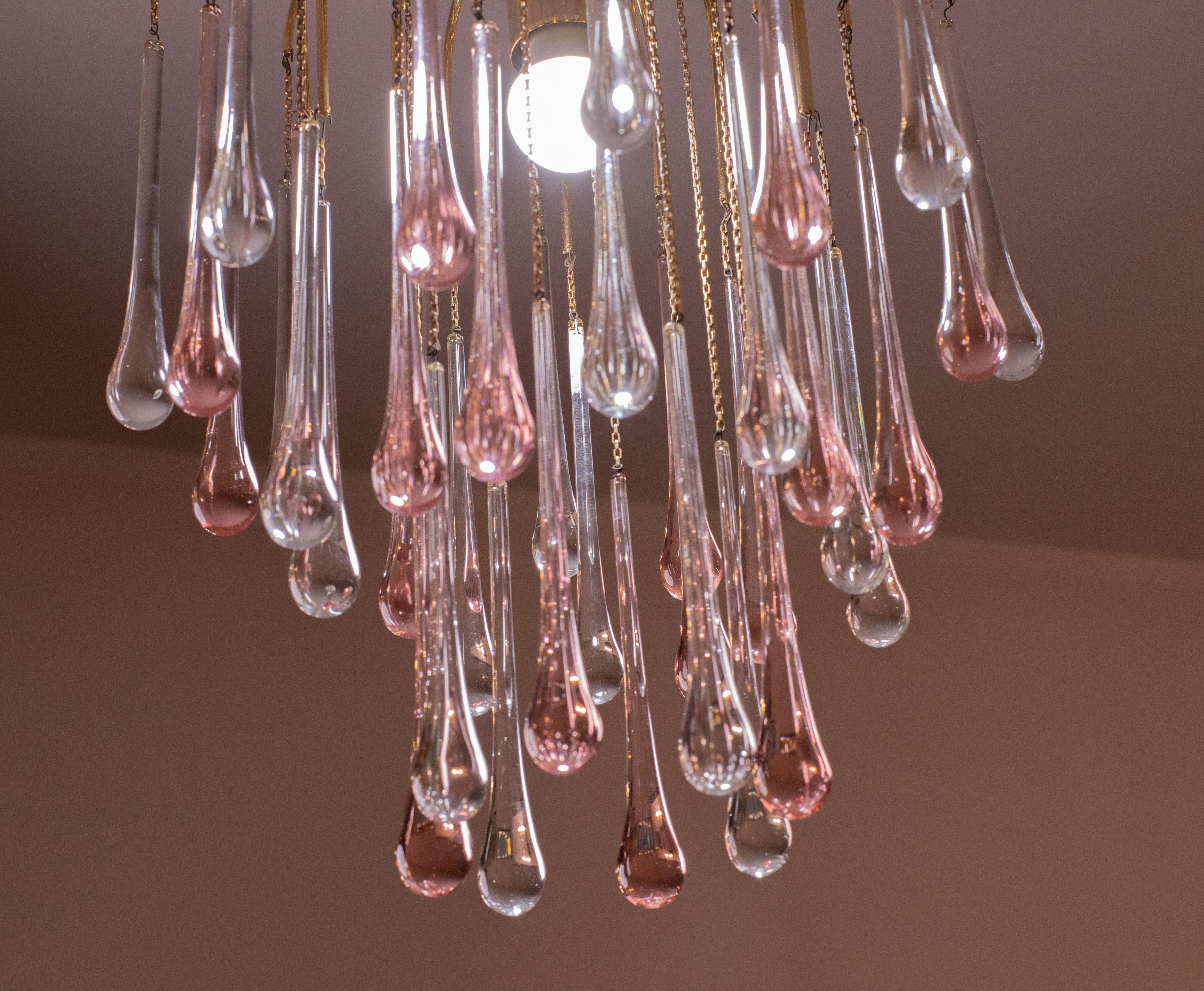 Gorgeous Murano chandelier in the style of Venini La Cascata.
The chandelier consists of three rounds composed of beautiful transparent and pink drops cascading down.
The chandelier consists of 1 e27 light points, the frame is in gold bath, in