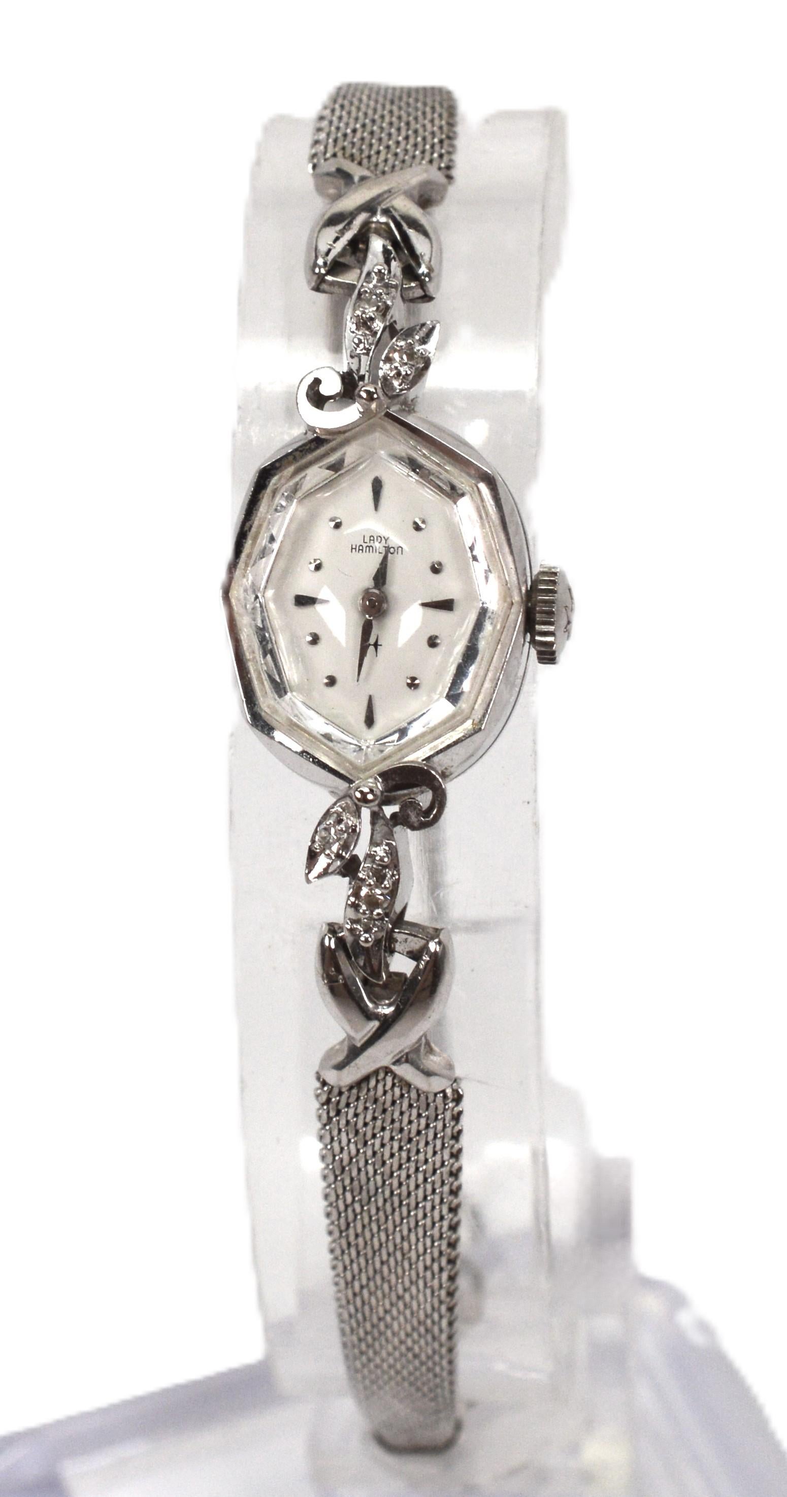 Eleg inimitable du milieu du 20ème siècle, profitez de ce modèle ultra féminin.  Montre-bracelet Lady Hamilton Cocktail modèle 761 en or blanc 14 carats avec accents de diamants. Le boîtier octogonal de 17 x 14 mm aux lignes fines et délicates est