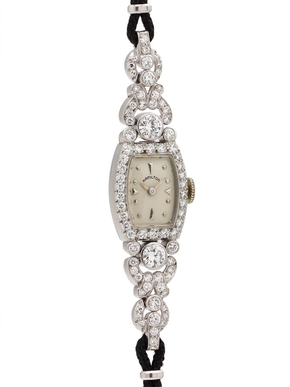 
An especially pretty design, lady Hamilton diamond encrusted hinged platinum case lady circa 1950's. Featuring a tonneau shaped case surrounded in modern brilliant cut bezel-set round diamonds, approximately 1.50 carat total weight , VS-SI/F-G.