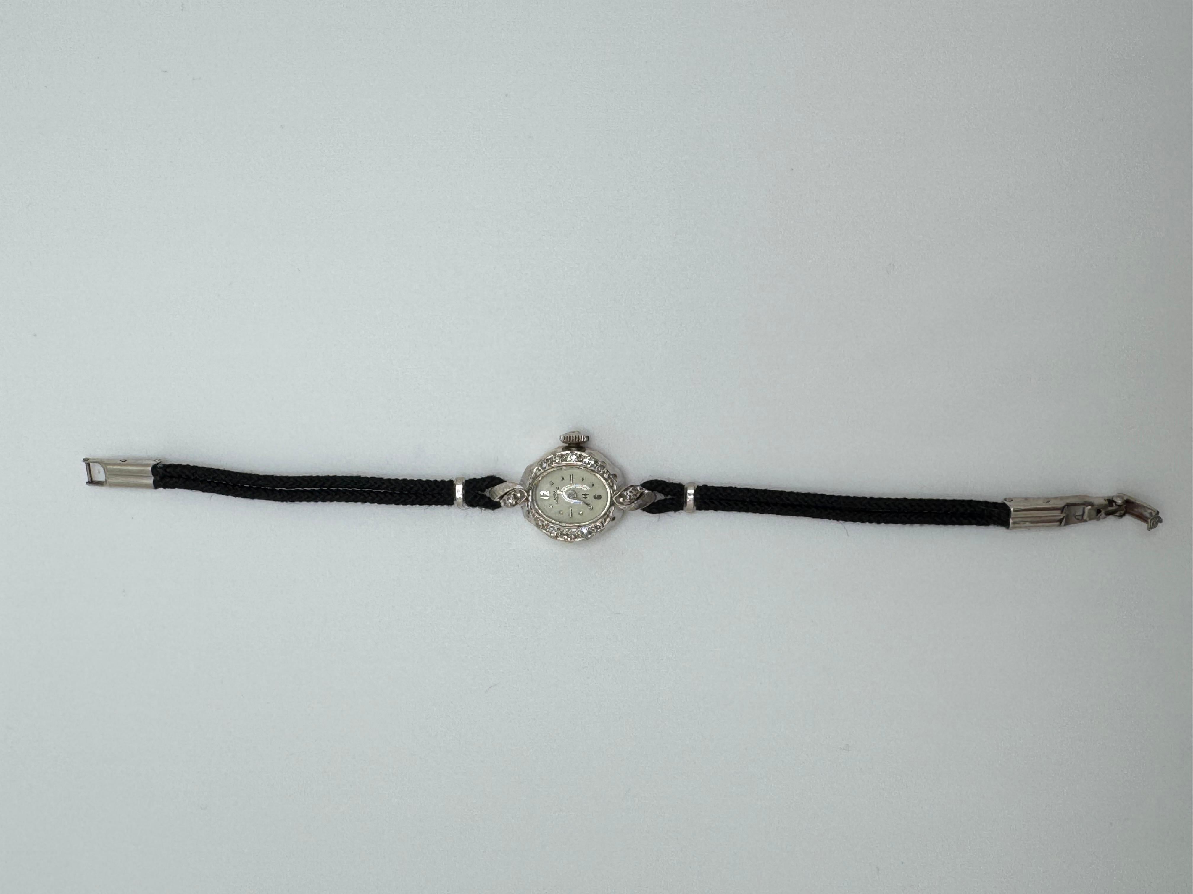 This elegant Lady Hamilton watch is crafted in 14KT white gold and showcases timeless vintage charm. The bezel is adorned with 12 round diamonds, square-cut and prong-set, adding a refined sparkle to the piece. Its delicate case reflects Hamilton’s