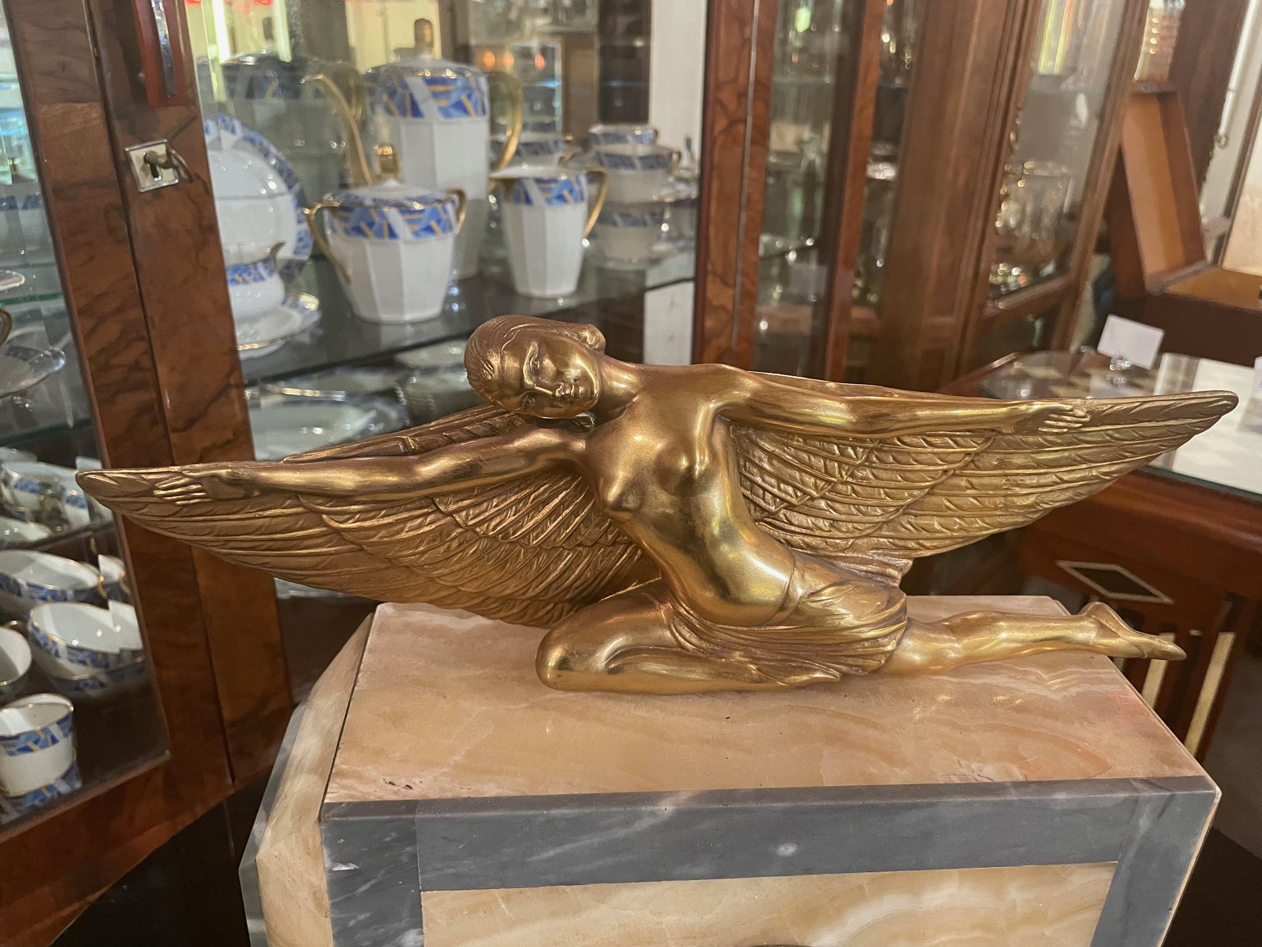 Lady Icarus gilded Art Deco statue adorns French marble clock. A beautiful rendition of the female form of Icarus with Art Deco-style wings spread across the top of this lovely serene female form. Her head is set back in a special way as she
