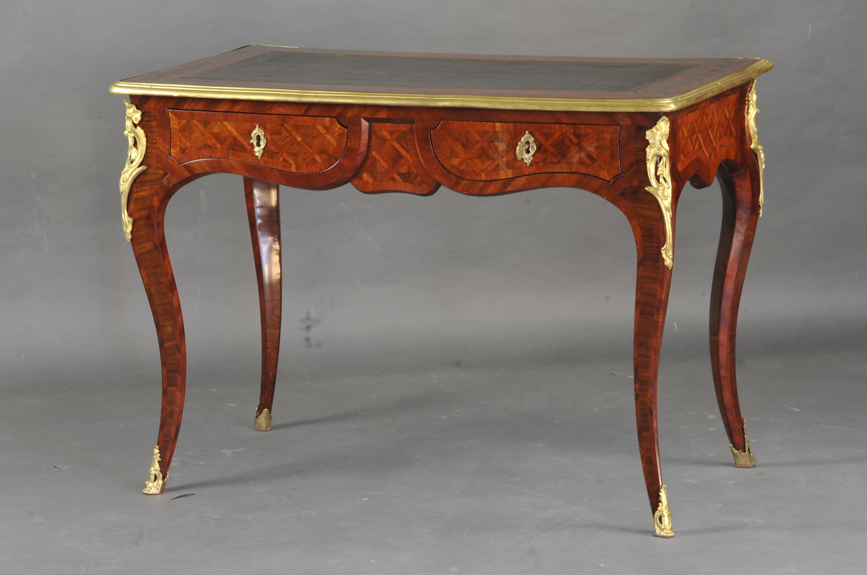 Lovely little center desk in violet wood marquetry decorated with braces, with beautiful finely chiseled gilt bronze ornamentation and an inlaid top adorned with fawn leather decorated with a golden frieze, all encircled in an ingot mold.

Opening