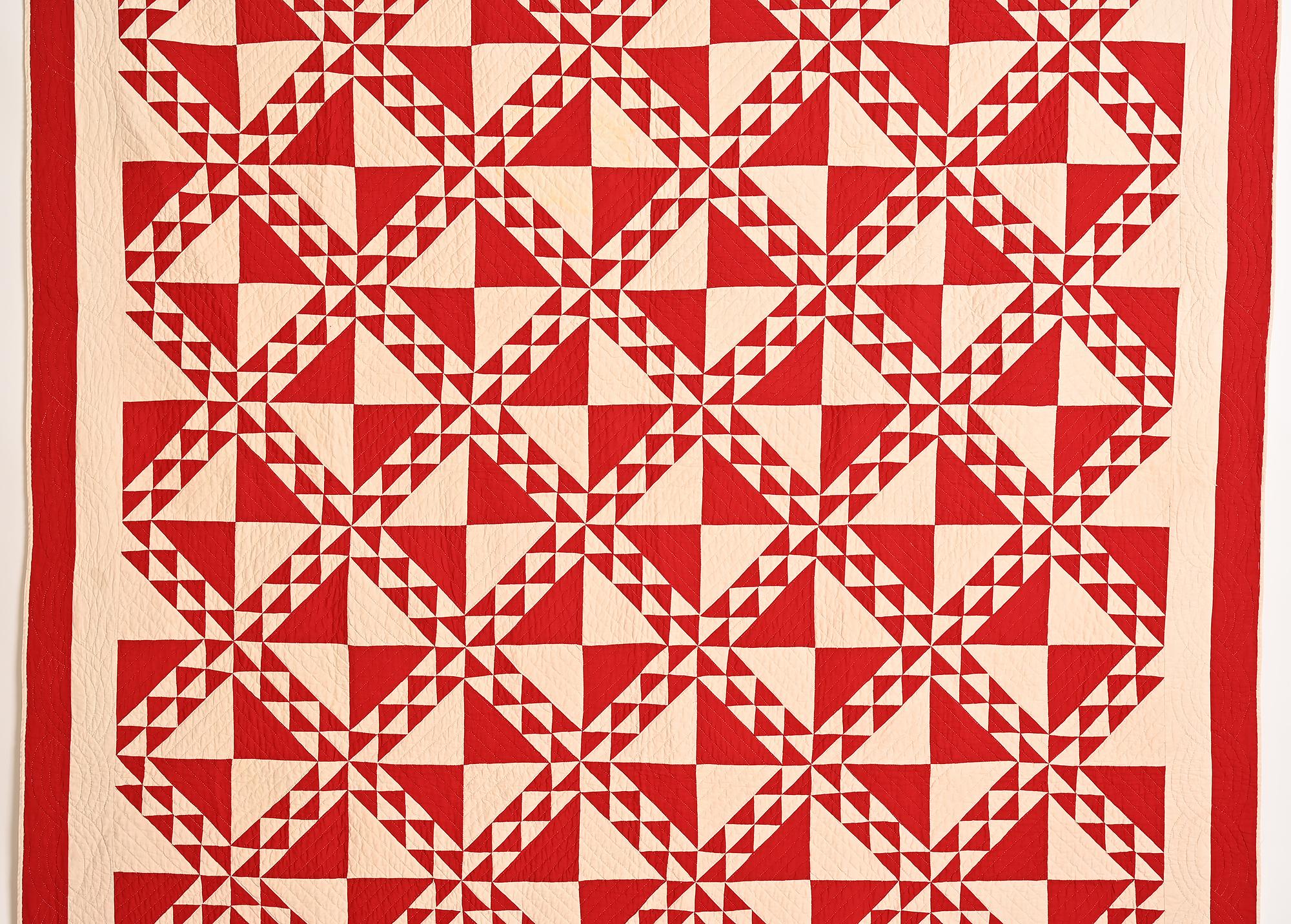 Lady of the Lake can best be described as a more complex version of the Ocean Waves pattern. Rather than the usual open center to each large block, it is divided into four triangles. The solid red of this example makes for an especially dynamic