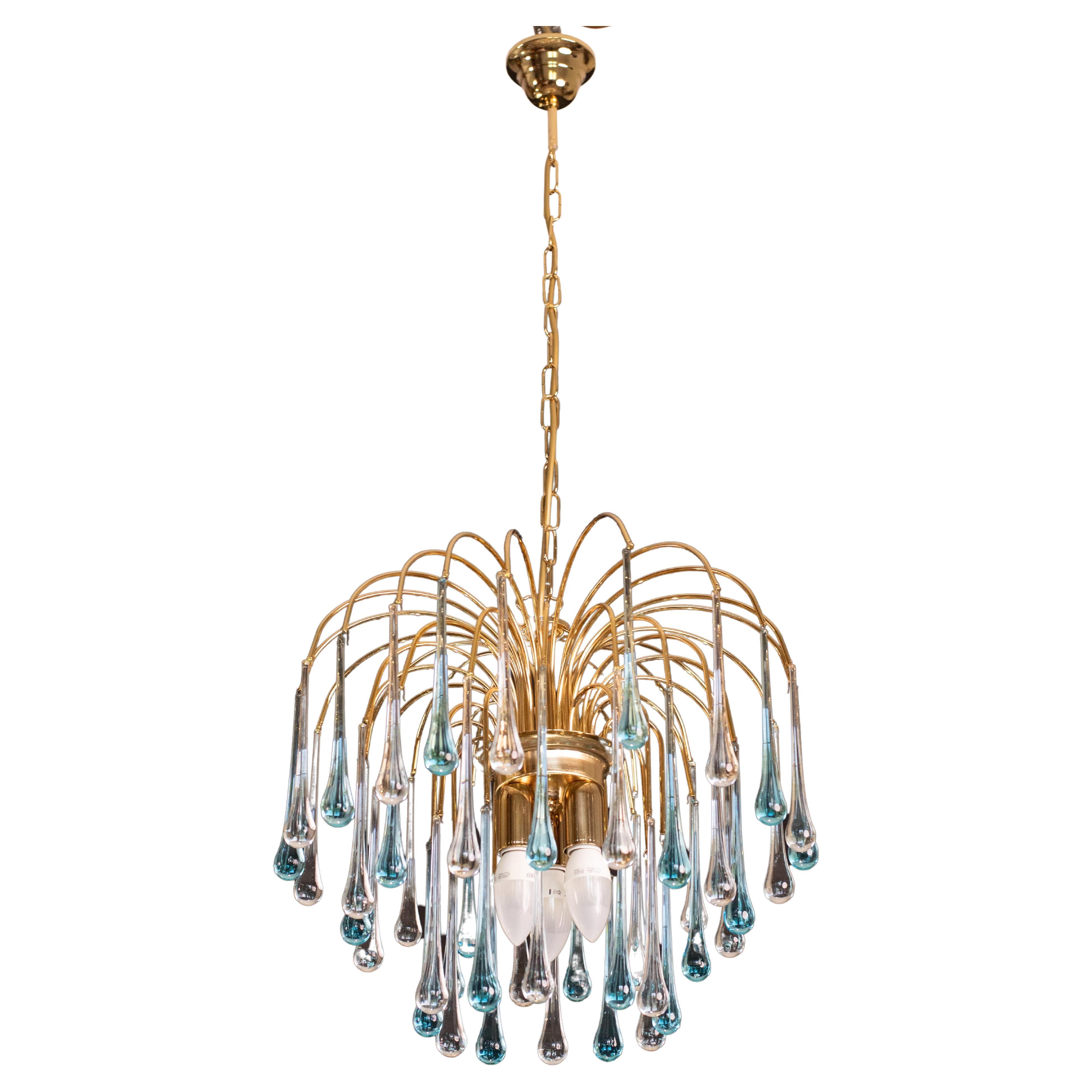 Gorgeous Murano chandelier in the style of Venini La Cascata.
The chandelier consists of three rounds composed of beautiful transparent and blu drops cascading down.
The chandelier consists of 3 e14 light points, the frame is in new gold bath.
The