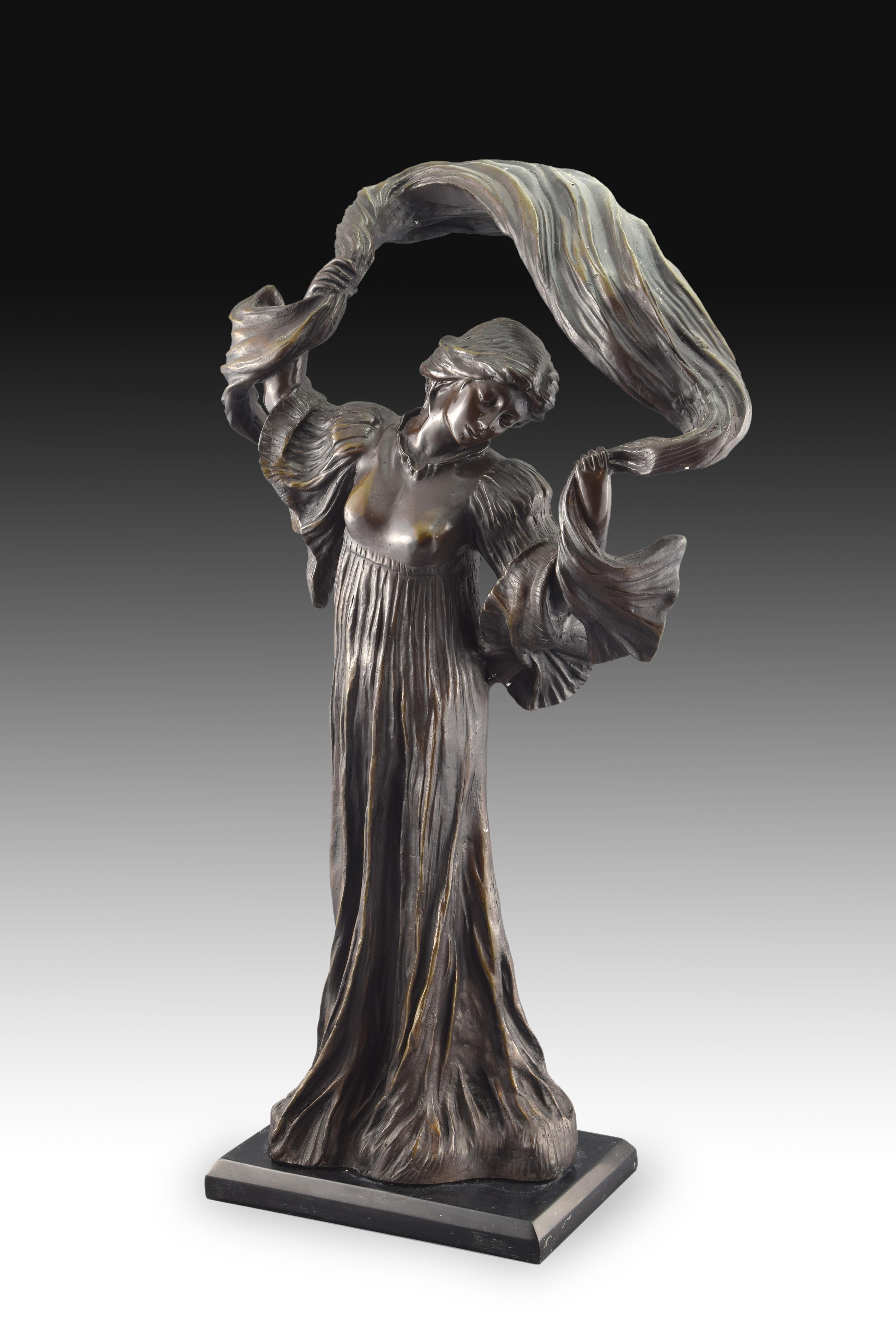 On a small rectangular base stands the female figure, who appears dressed in an outfit that reaches the ground, with long and moved sleeves and the bust closest to the body, and waving a shawl over her head. This piece is inspired by a well-known