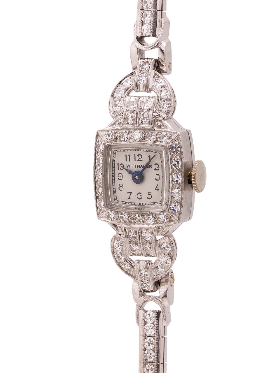 
An especially pretty design, lady Wittnauer diamond encrusted hinged platinum case lady circa 1940’s. Featuring a square shaped case surrounded in diamonds, highlighted with 2 diamond set “lugs” fixed to the the body of the case. With pleasing snow
