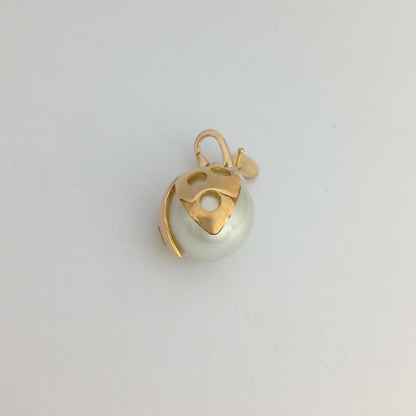 A very beautiful Australian pearl has been carefully crafted to make a ladybug, It is often used as a lucky charm. 
The ring for the necklace is a carabiner so it can be worn also as a beautiful charm on a bracelet.  
The gold is red.
The diameter