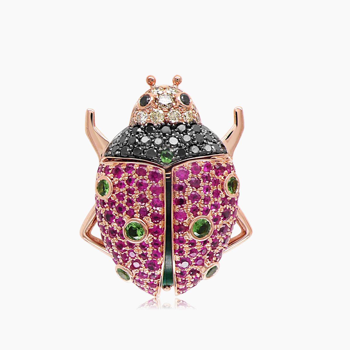 Cette bague complexe est réalisée en or rose 18 carats. Il présente des rubis roses vibrants totalisant 2,0 carats, rehaussés de 0,54 carats de diamants noirs.
Le motif est encore rehaussé de grenats verts.
La pièce mesure 2,4 cm de long, 2,9 cm de
