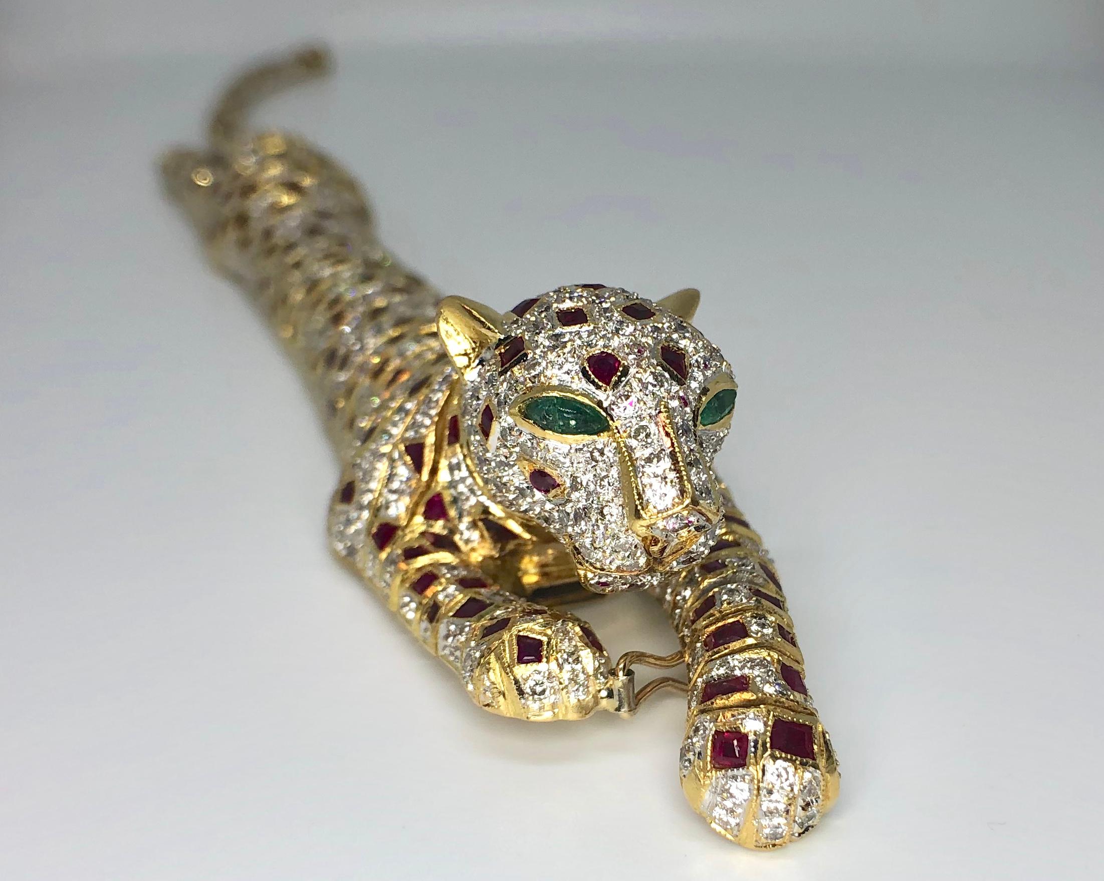 Lady's 18 Karat Yellow Gold Diamond, Ruby and Emerald Panther Bracelet / Brooch. This custom-made panther is jointed along its entire length to allow the bracelet to drape around the wrist. It can also be worn as a brooch for an impressive accent to