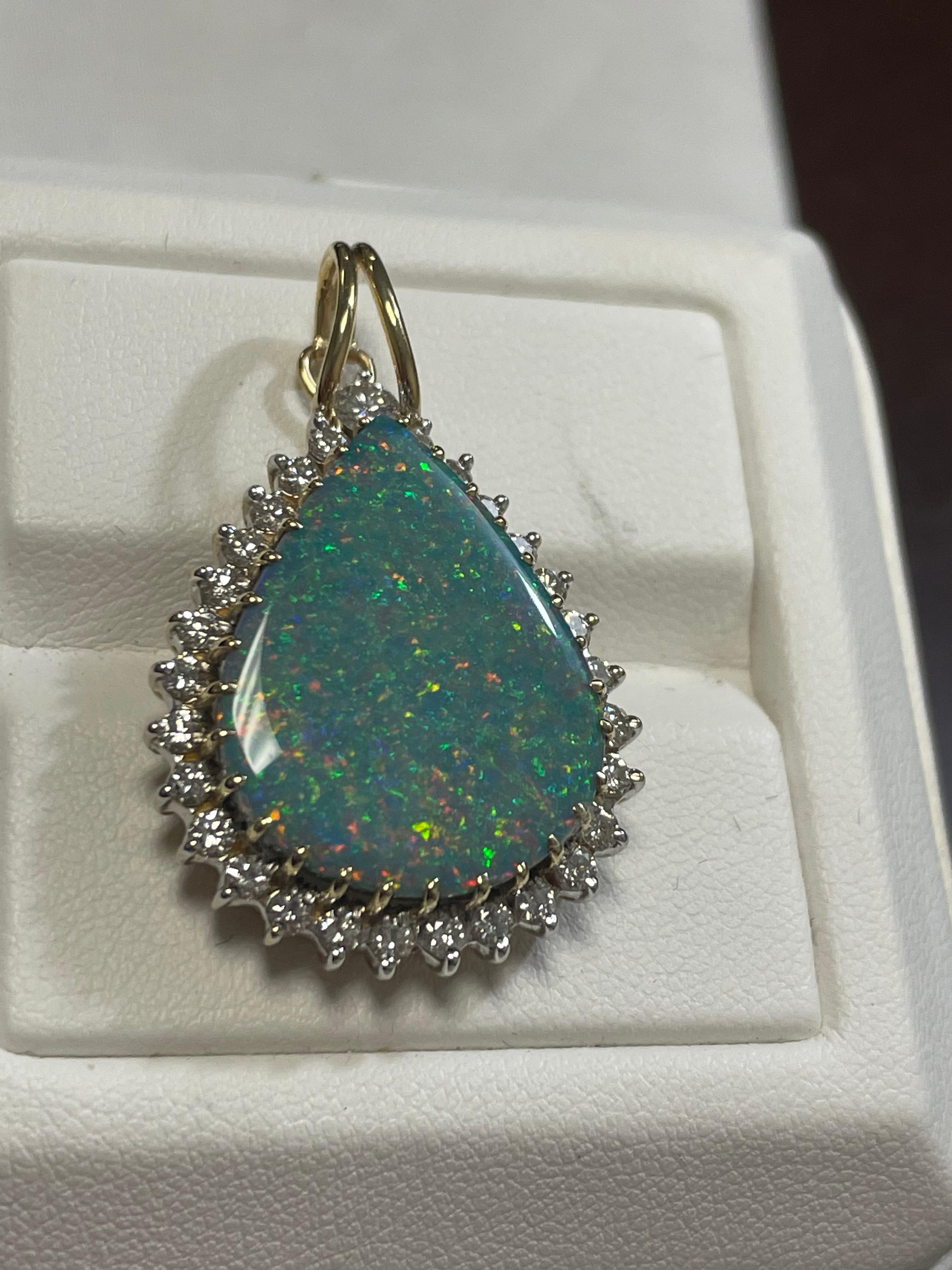 One lady's black opal with multicolor fire color. Saturation scale is average with a pin fire pattern.  Bright with cabochon, pear shape. 28 round brilliant-cut diamonds measuring 2.2 mm. One round brilliant cut measuring 3.3 mm.  Total weight is