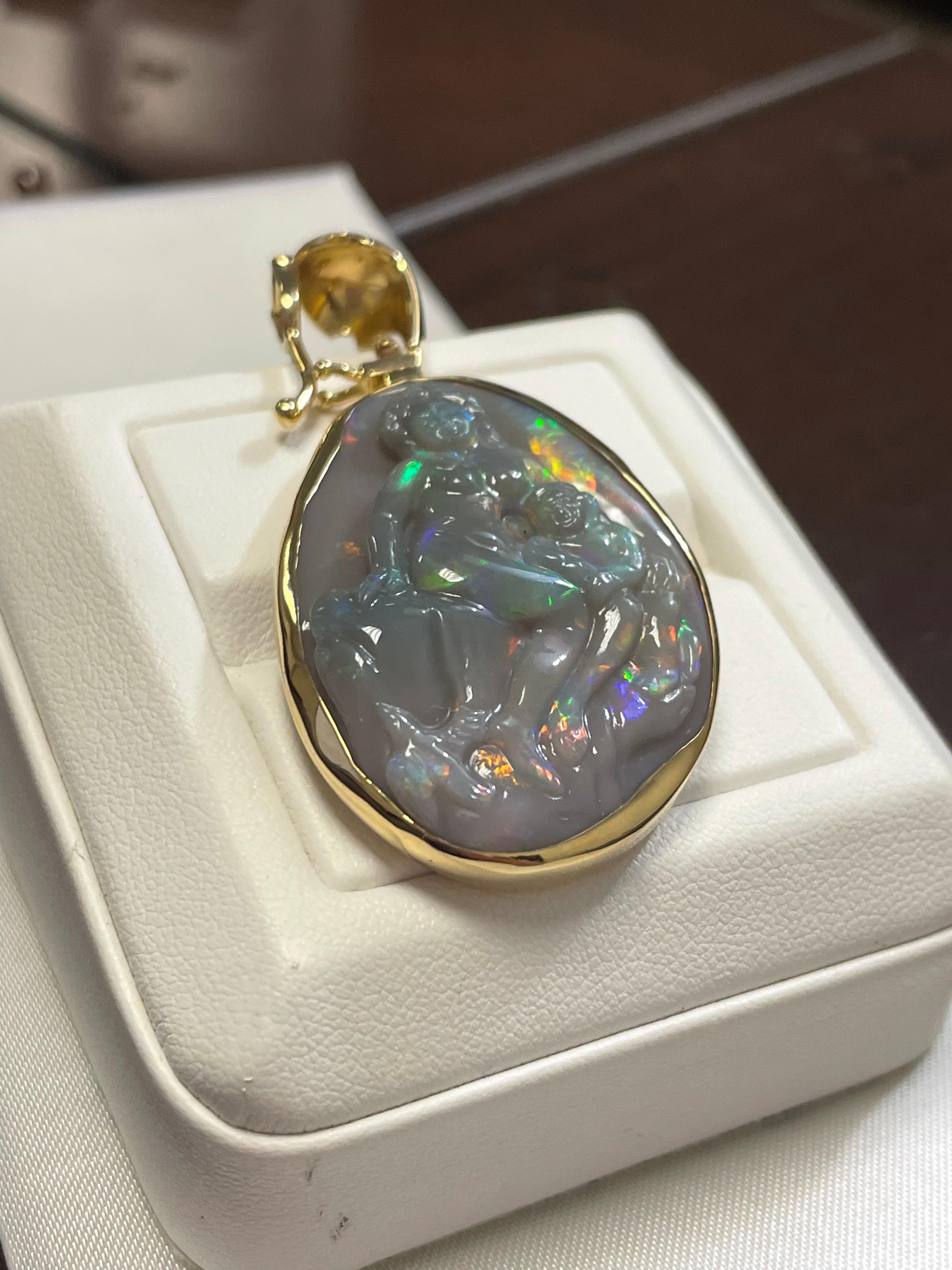 One lady's gray opal with a blue-green fire color.  Saturation scale is average with a flash fire pattern.  Bright with cabochon, freeform carving shape.  Measurements are 41.5 mm x 27.0 mm.  Pendant is hand made in 18k yellow gold. 