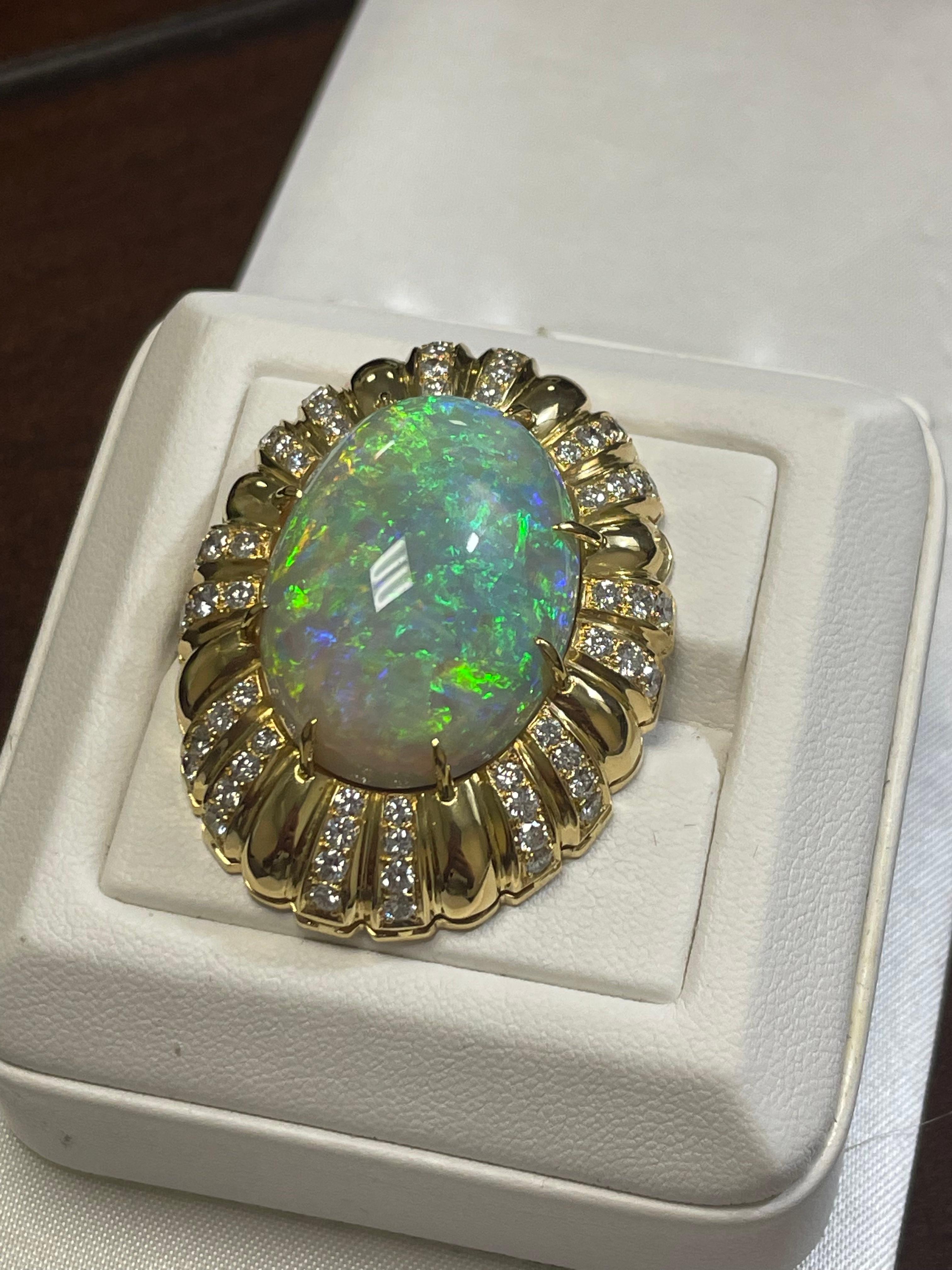 One lady's semi-crystal opal with multicolor fire color.  Saturation scale is average with a flash fire pattern.  Very bright, cabochon, oval shape.  Measurements are 29.0 x 21.0.  64 round brilliant-cut diamonds measuring 2.3-2.5 mm.  Total weight