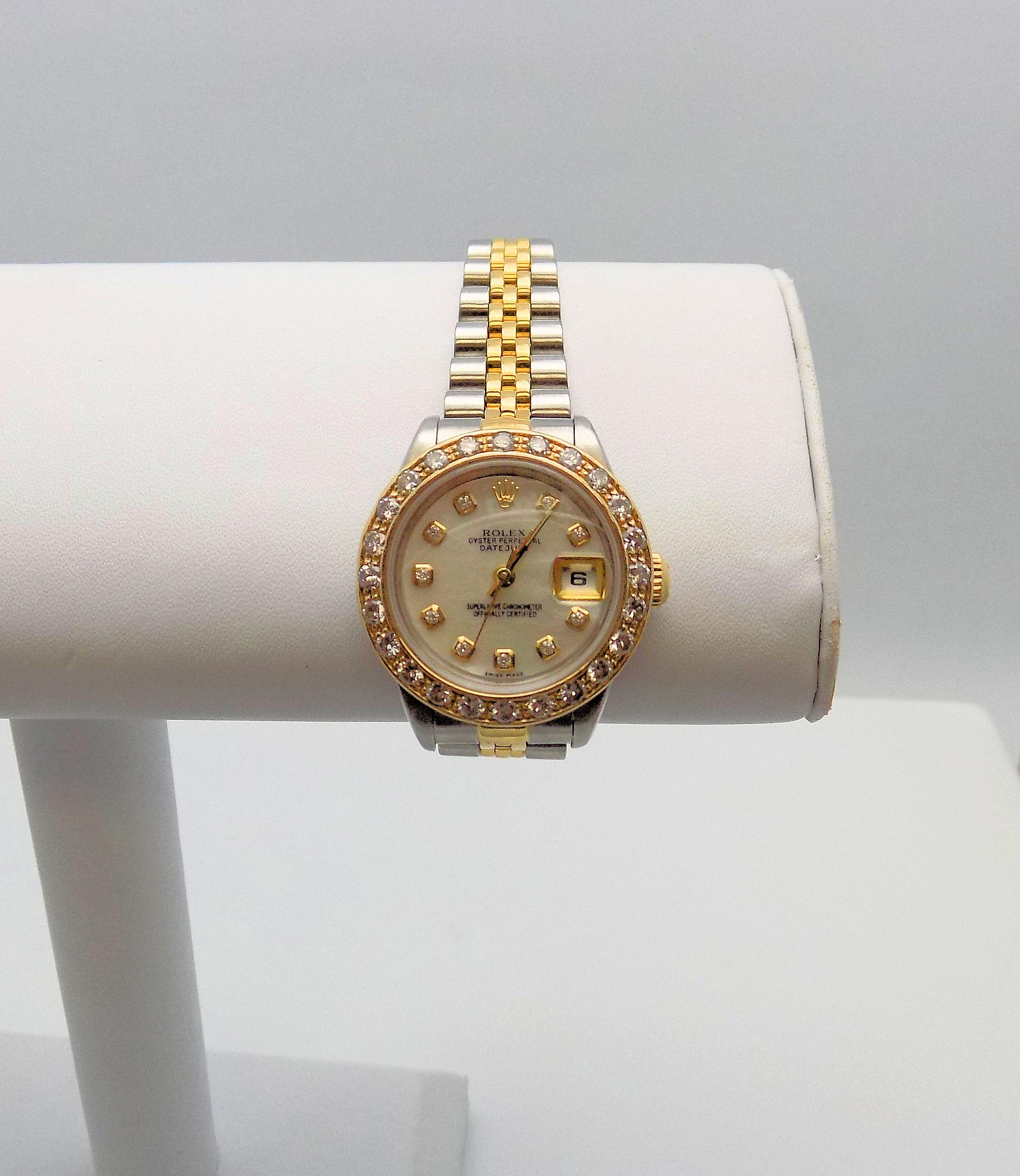 Classic 18 Karat Yellow Gold and Stainless Steel Lady's Wrist Watch by Rolex featuring Oyster Perpetual Date Just Mother of Pearl Dial, 10 Round Brilliant Diamonds, (After Market Bezel) 24 Round Brilliant Diamonds 1.25 Carat Total Weight, SI, H, 1
