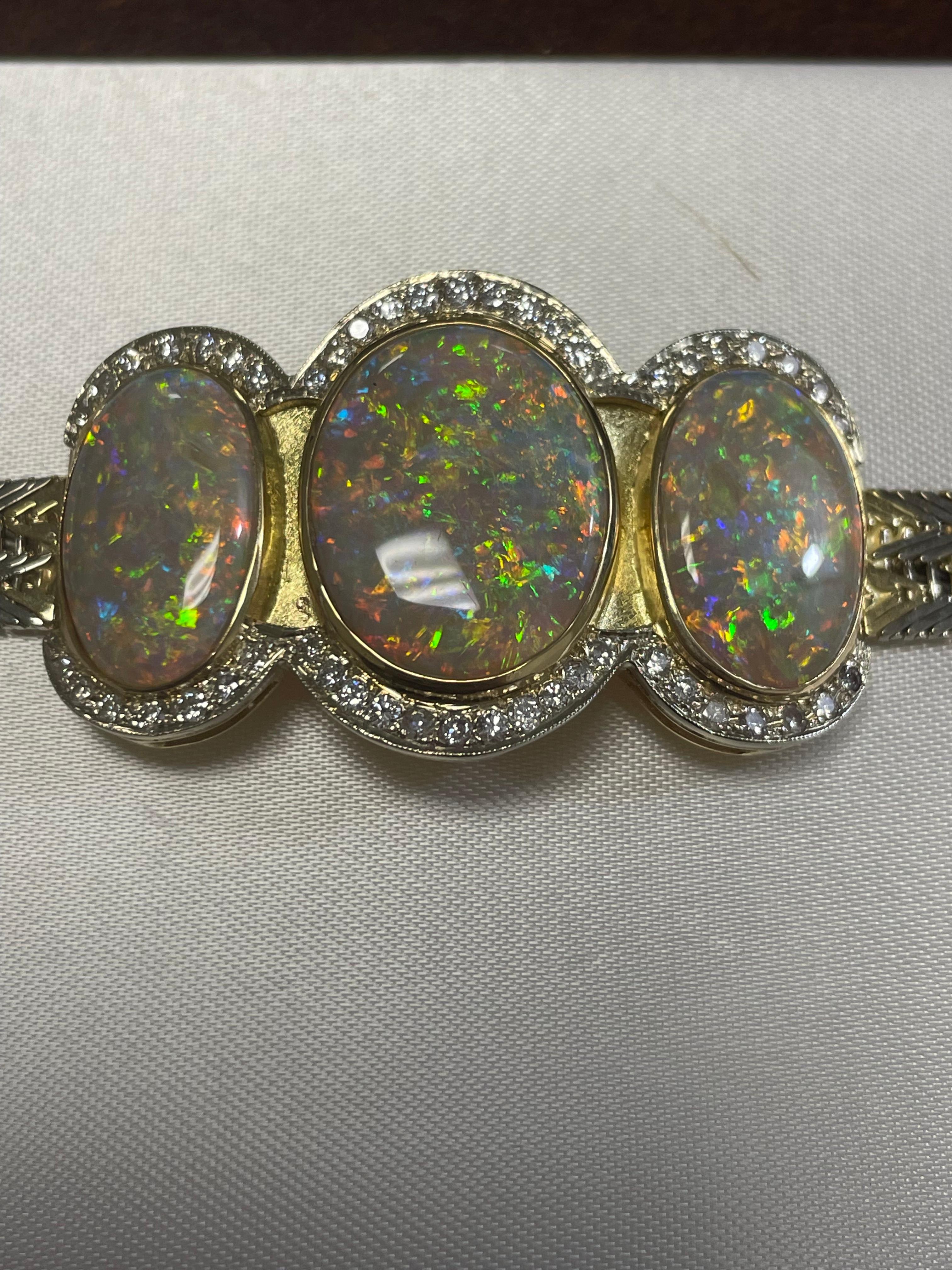 One lady's semi-black opal with multi color fire color.  Saturation scale is average with a pin fire pattern.  Bright, cabochon, oval shape.  Measurements are (1) 20.0 x 15.5 mm (2) 18.0 x 12.0 mm.  50 round brilliant cut diamonds measuring 1.7 mm. 
