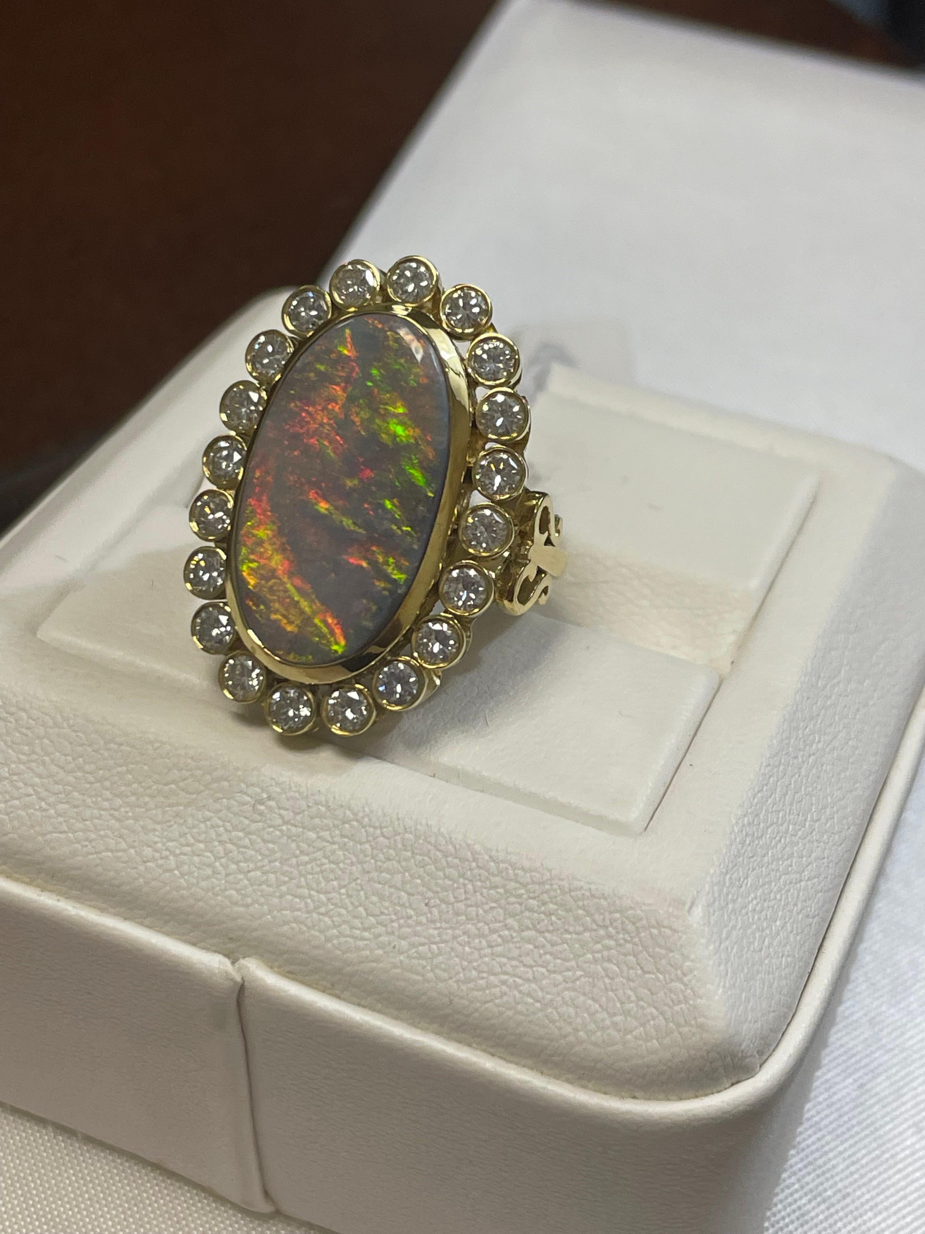 One lady's semi-black opal with orange-red fire color.  Saturation scale is average with a flash fire pattern.  Brightness of fire is quite-bright with cabochon, oval shape.  Measurements are 20.5 x 11.6 mm. Weight is 9 carats.  20 round