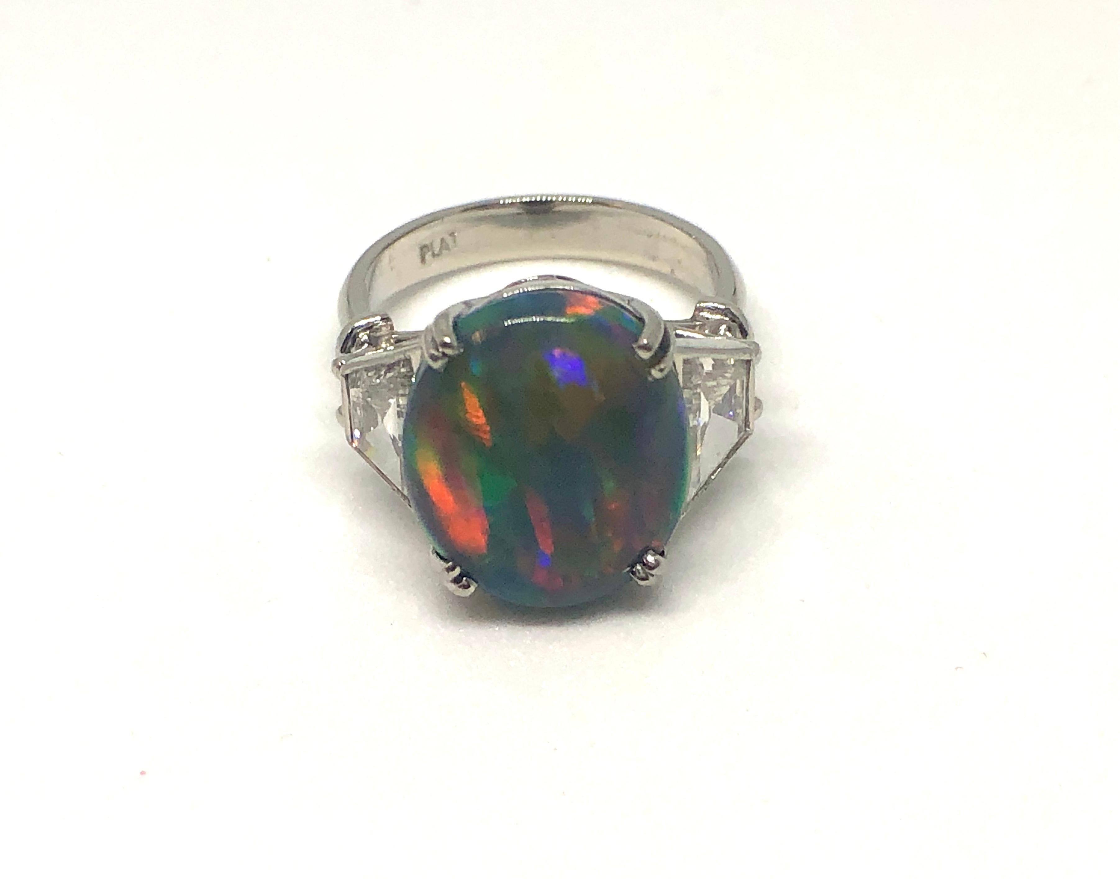 This lady's ring boasts an impressive and vibrant 5.58 carat black opal that displays a fine play of color with a very good to fine grade. It is flanked by two shield cut diamonds that = 1.20 carat set in platinum.

Opal Quality

Colour Black
Cut