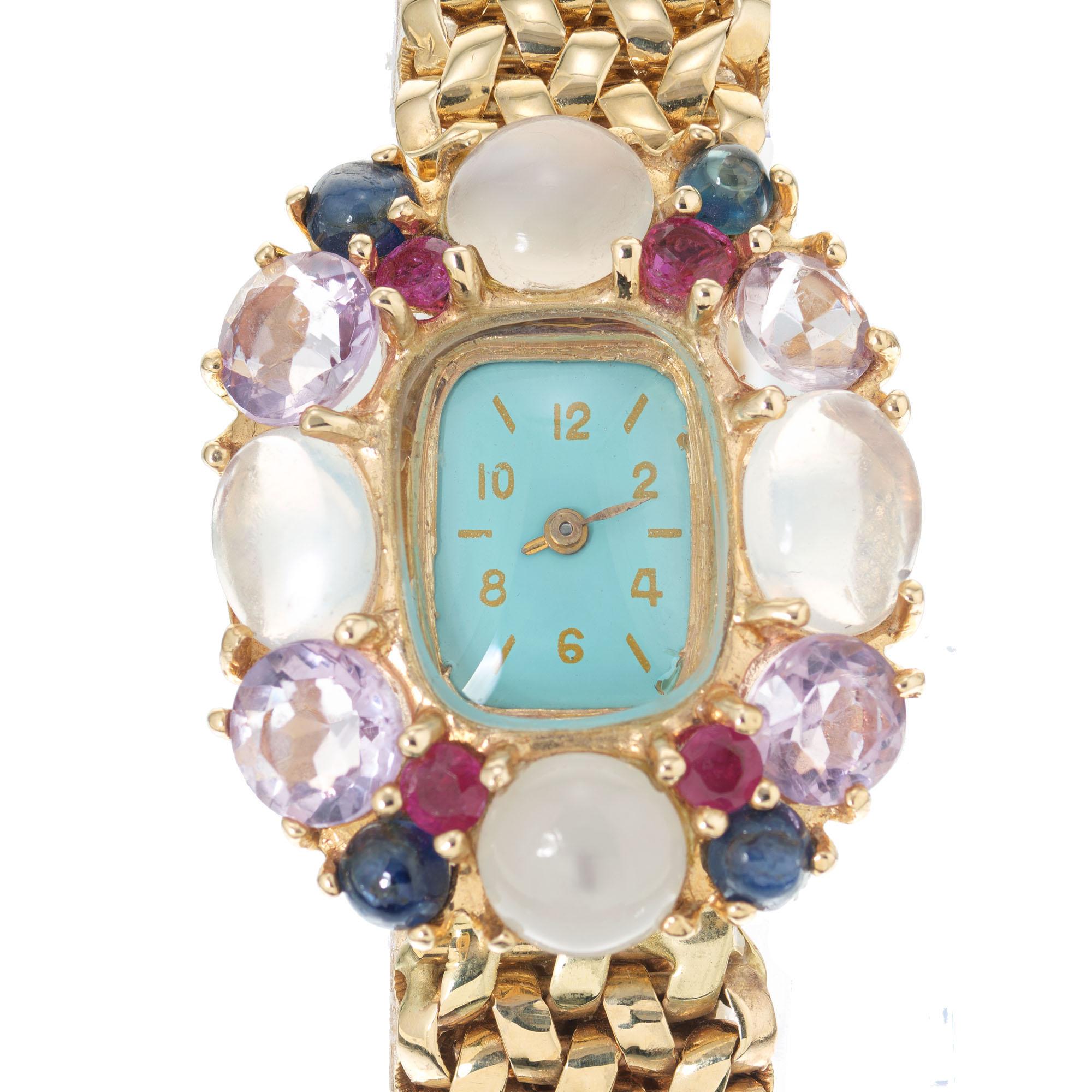 Mid-Century Lady's 14k yellow gold watch with a halo of natural stones, ruby, sapphire, amethyst and moonstone, with a 17-jewel manual-wind movement and solid gold mesh Kreisler bracelet. Turquoise blue dial, possibly refinished. 7.25 inches in