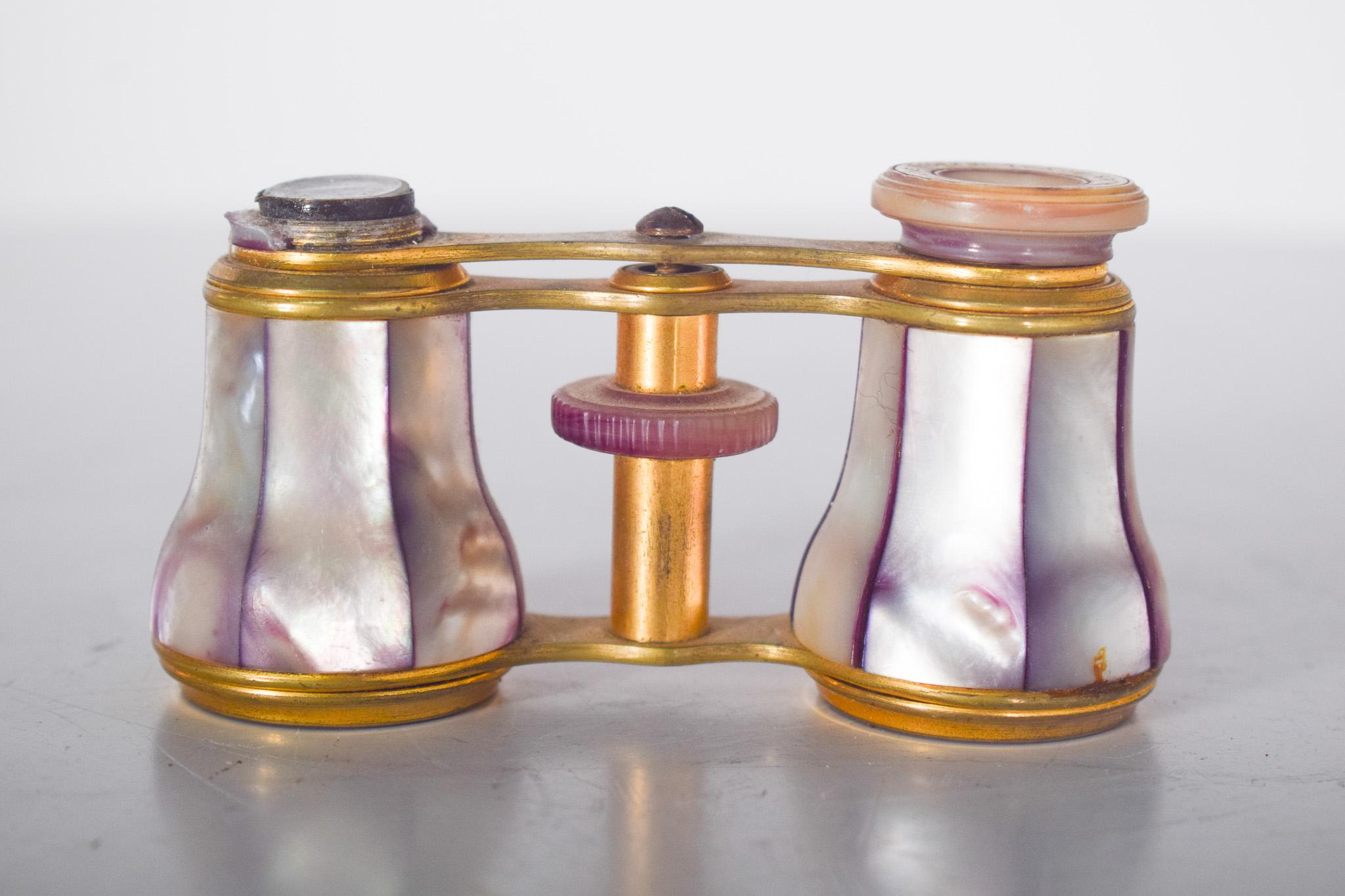 Lafontaine theatre binoculars in mother-of-pearl. They are small, light and designed to provide an enlarged view at events such as operas, theatres and concerts. The frame is made of gold-plated metal, while the optical tubes are coated with