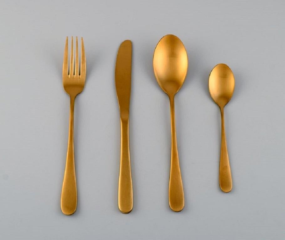 Lagerhaus, Sweden. Dinner service in brushed brass for twelve people. 
Swedish design, 21st Century.
Knife length: 22.5 cm.
In excellent condition.