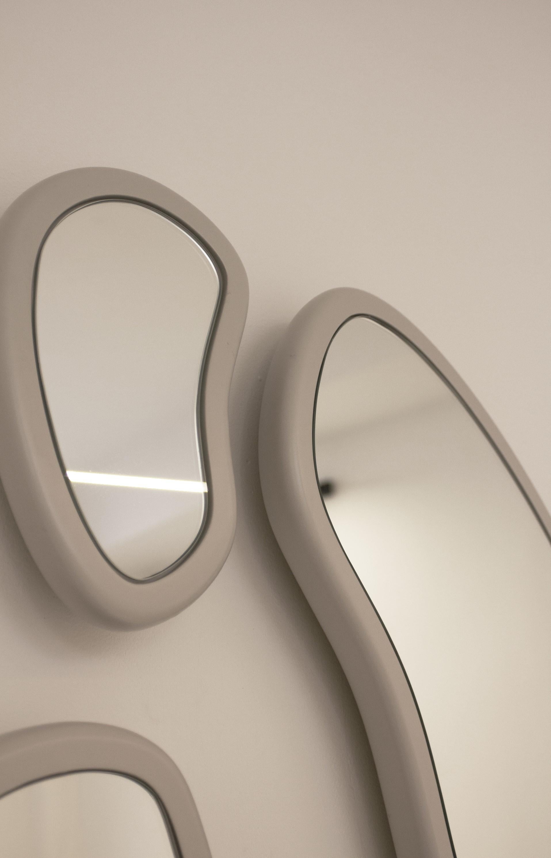 Les miroirs Laghi s'inspirent des différentes compositions réalisées par l'ensemble de tables basses Laghi. Grâce aux courbes internes et externes ainsi qu'aux différentes tailles de miroir, chaque composition peut être totalement unique. Les