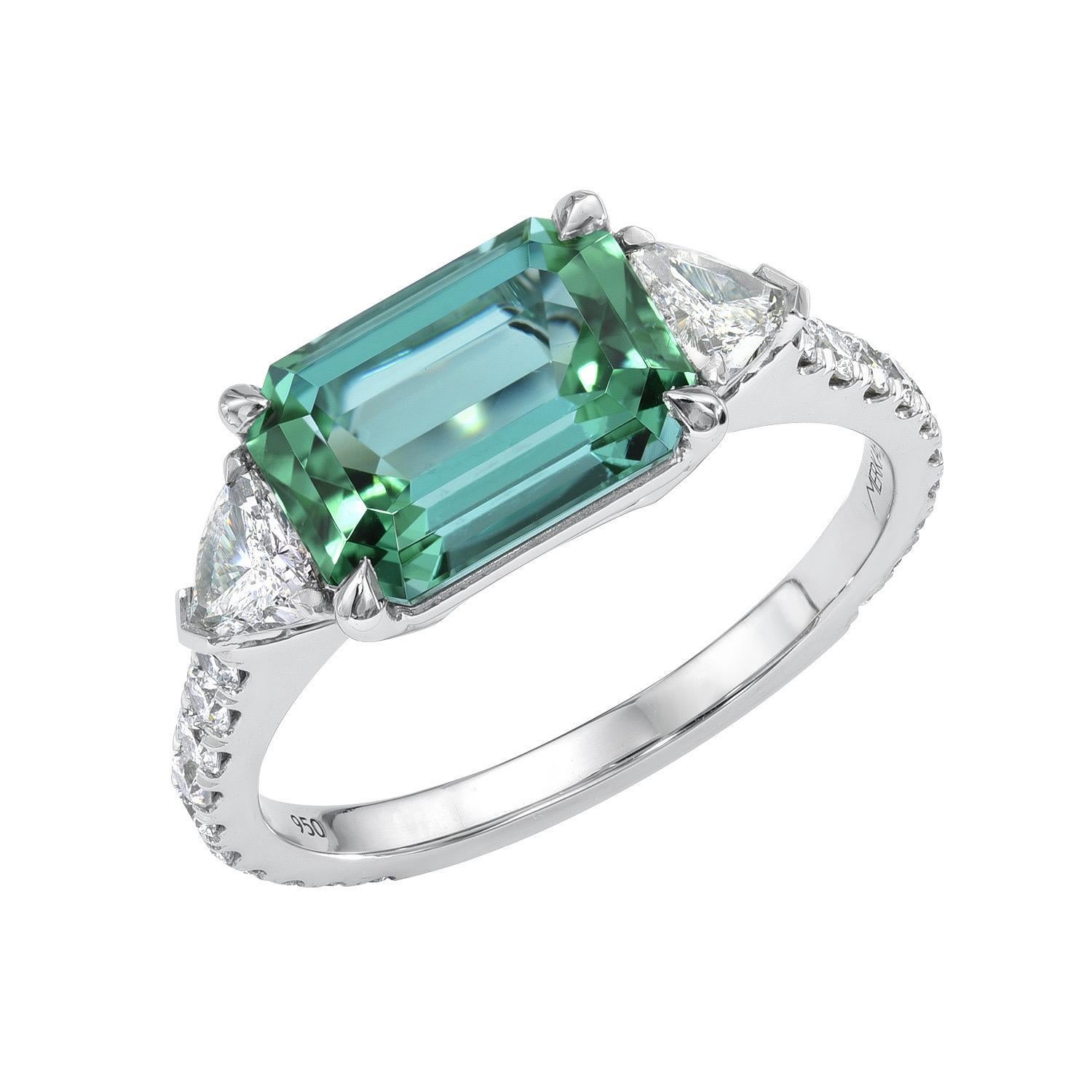 Exceptional 2.69 carat Lagoon Green Tourmaline Emerald-Cut platinum ring, flanked by a pair of 0.31 carat Trillion diamonds, and decorated with a total of 0.39 carat round brilliant diamonds.
Ring size 6.5. Resizing is complementary upon