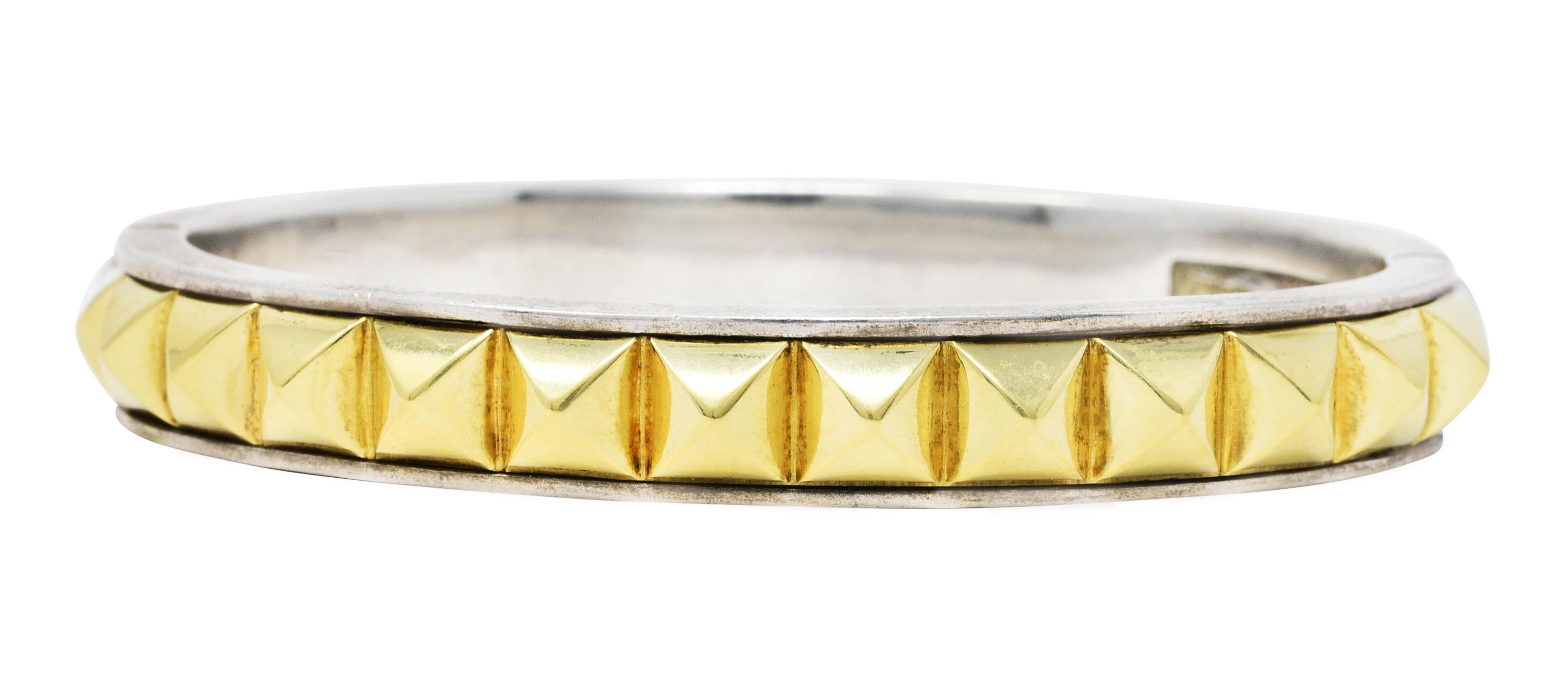 Bangle style bracelet with gold and silver pyramid studs completely around 

Opens on a hinge via presser and slide mechanism

Stamped 750 and 925 for 18 karat gold and sterling silver, respectively

Signed Caviar for Lagos

Caviar Collection -